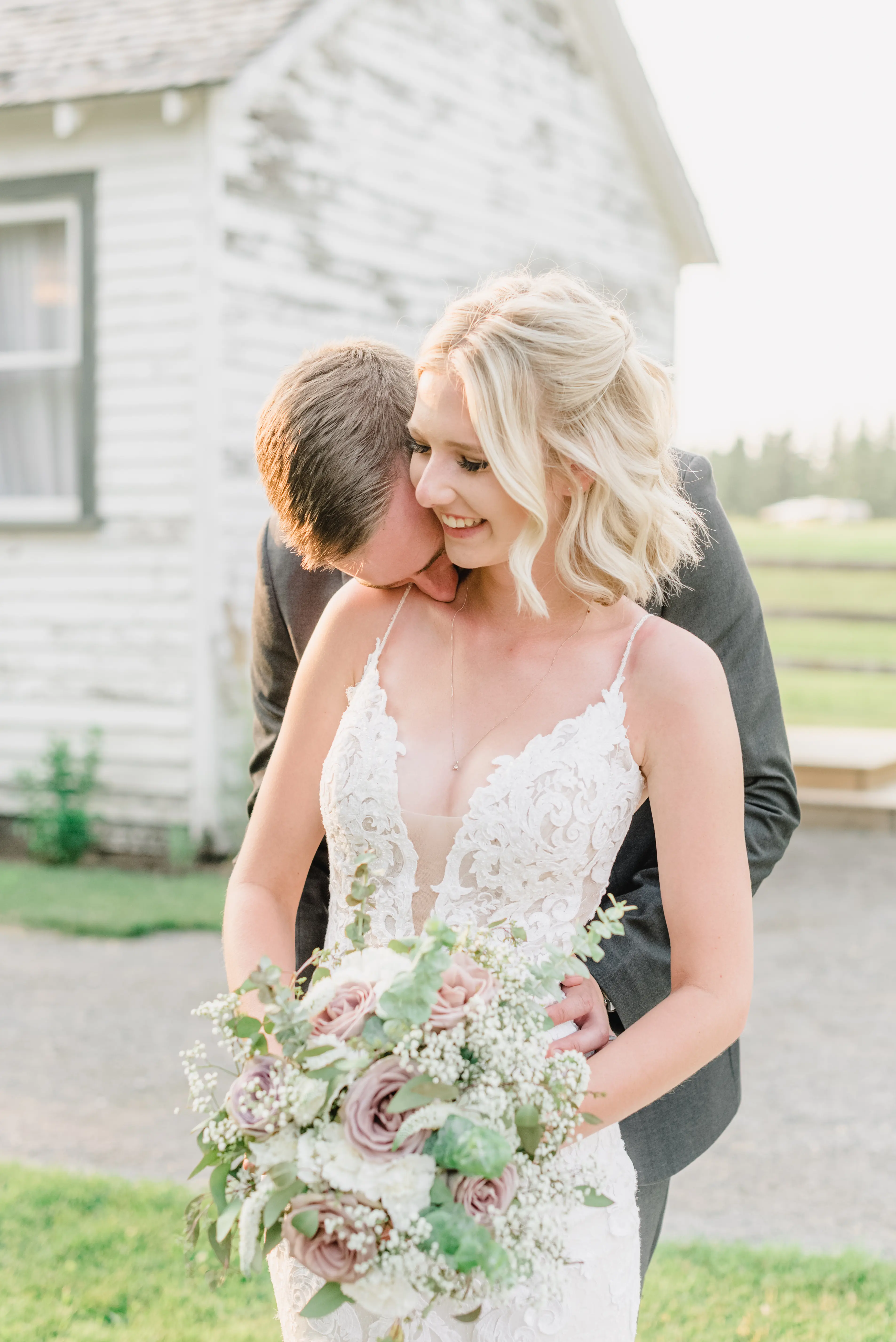Bride with groom wearing lace sheath wedding dress
