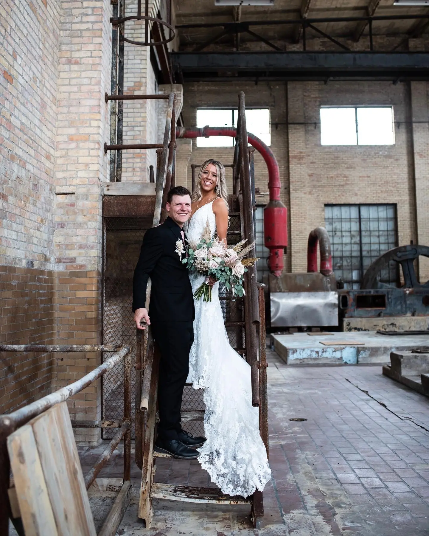 Bride with groom wearing romantic lace sheath wedding dress.