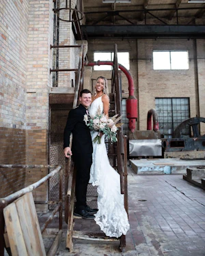 Bride with groom wearing romantic lace sheath wedding dress.
