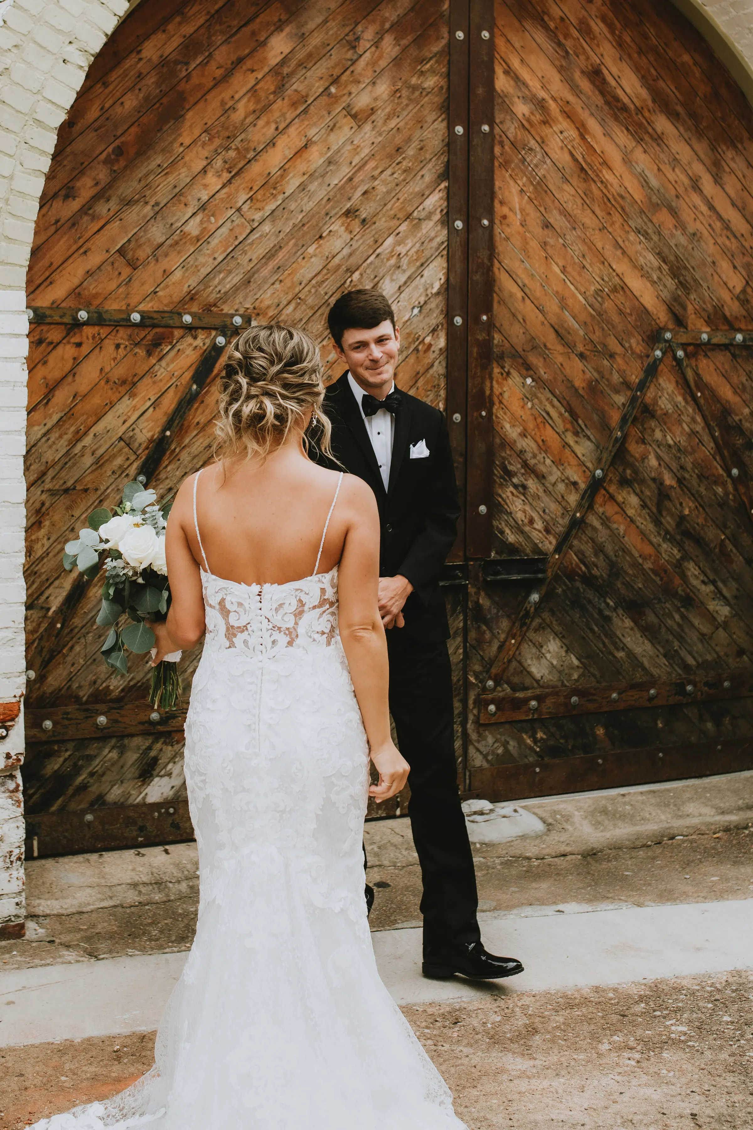 Bride with groom in romantic lace sheath wedding dress