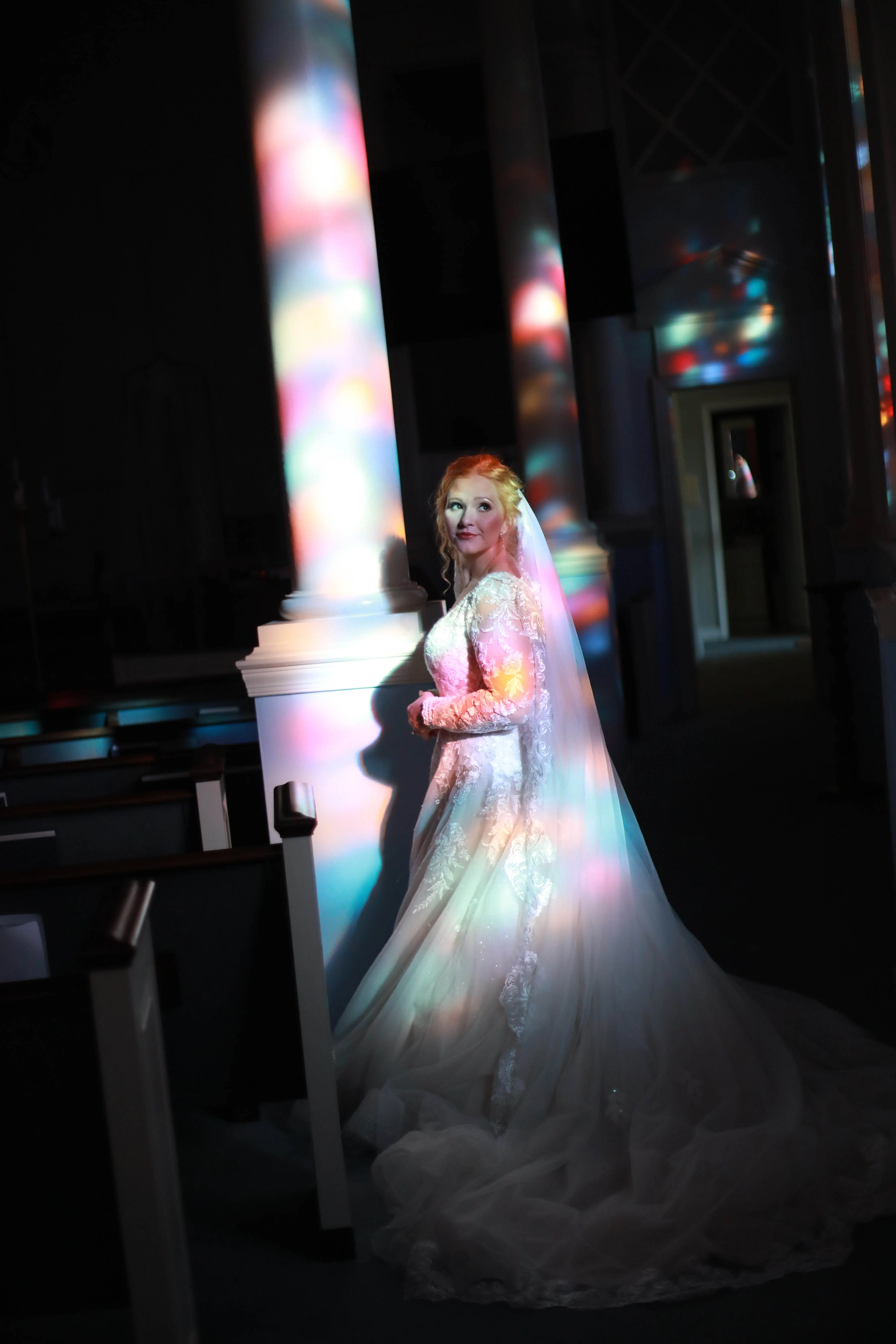 Bride Standing In Colorful Lights. Bride Wearing Romantic A-Line Long Sleeve Dress Called Raphael By Maggie Sottero