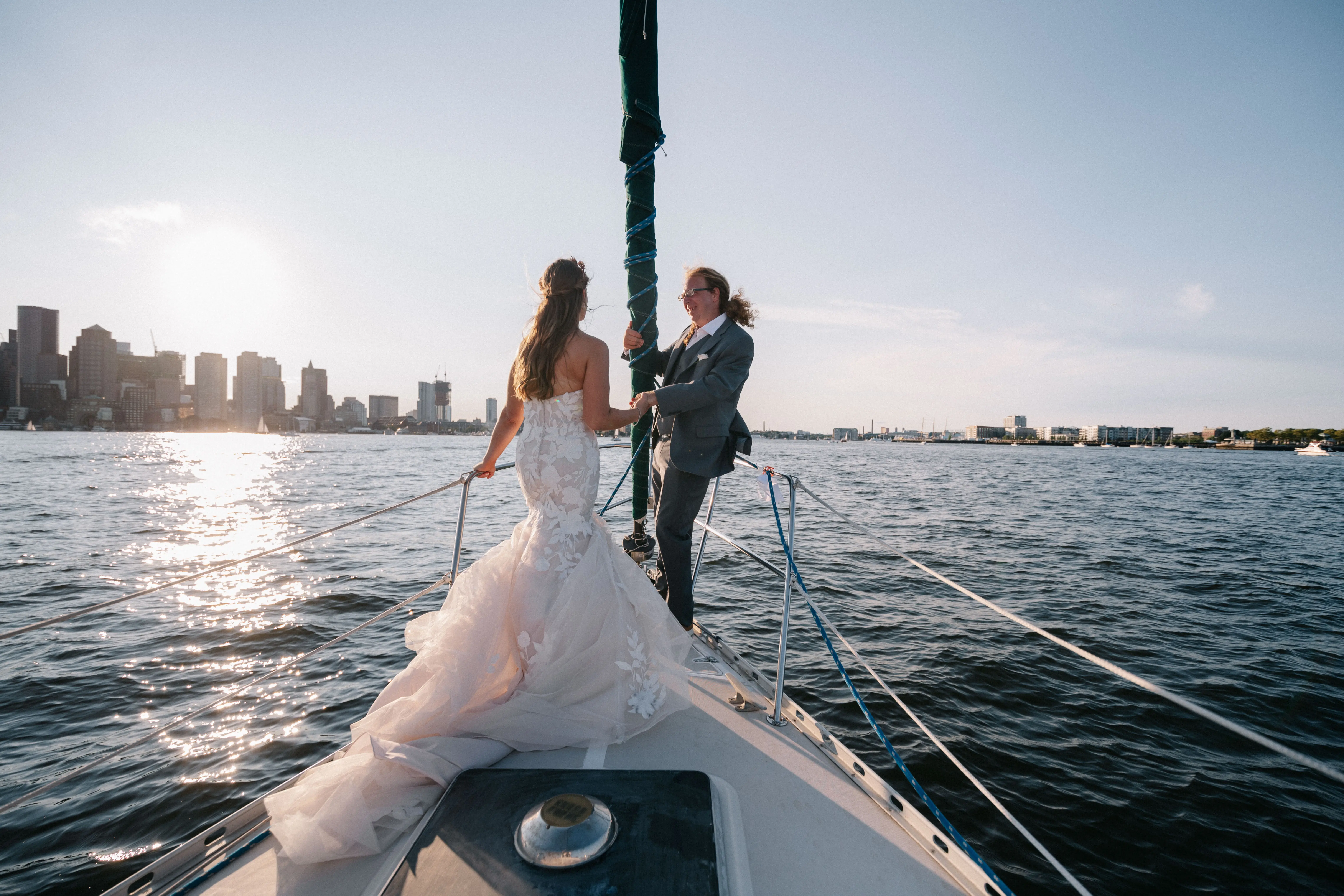 Bride with groom wearing strapless mermaid wedding dress with plunging V-neck.
