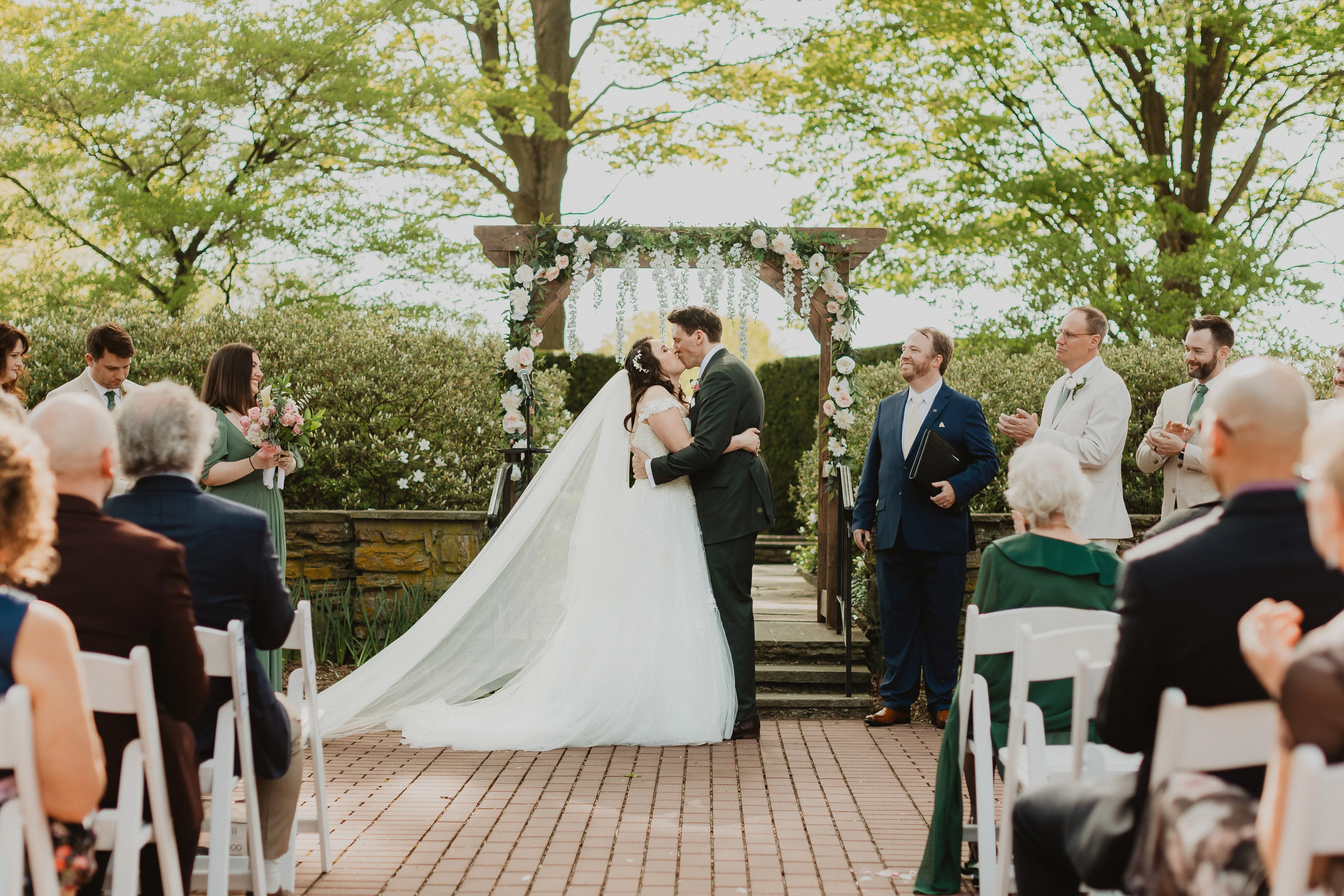 Bride wearing Mason by Sottero and Midgley kissing her husband during their ceremony