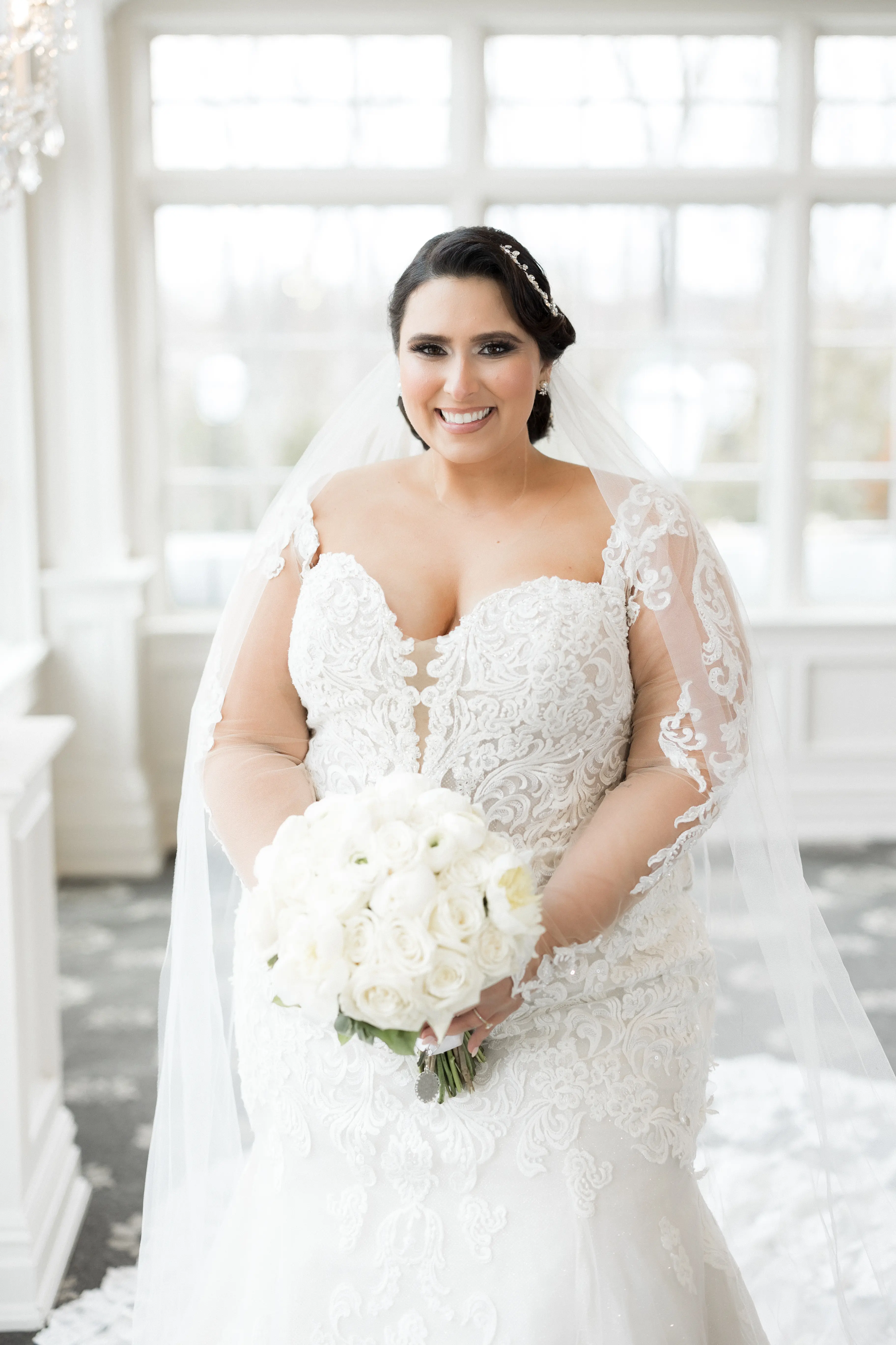 Bride Wearing Sexy Lace Long Sleeve Wedding Dress Called Fiona By Maggie Sottero Holding A White Bouquet