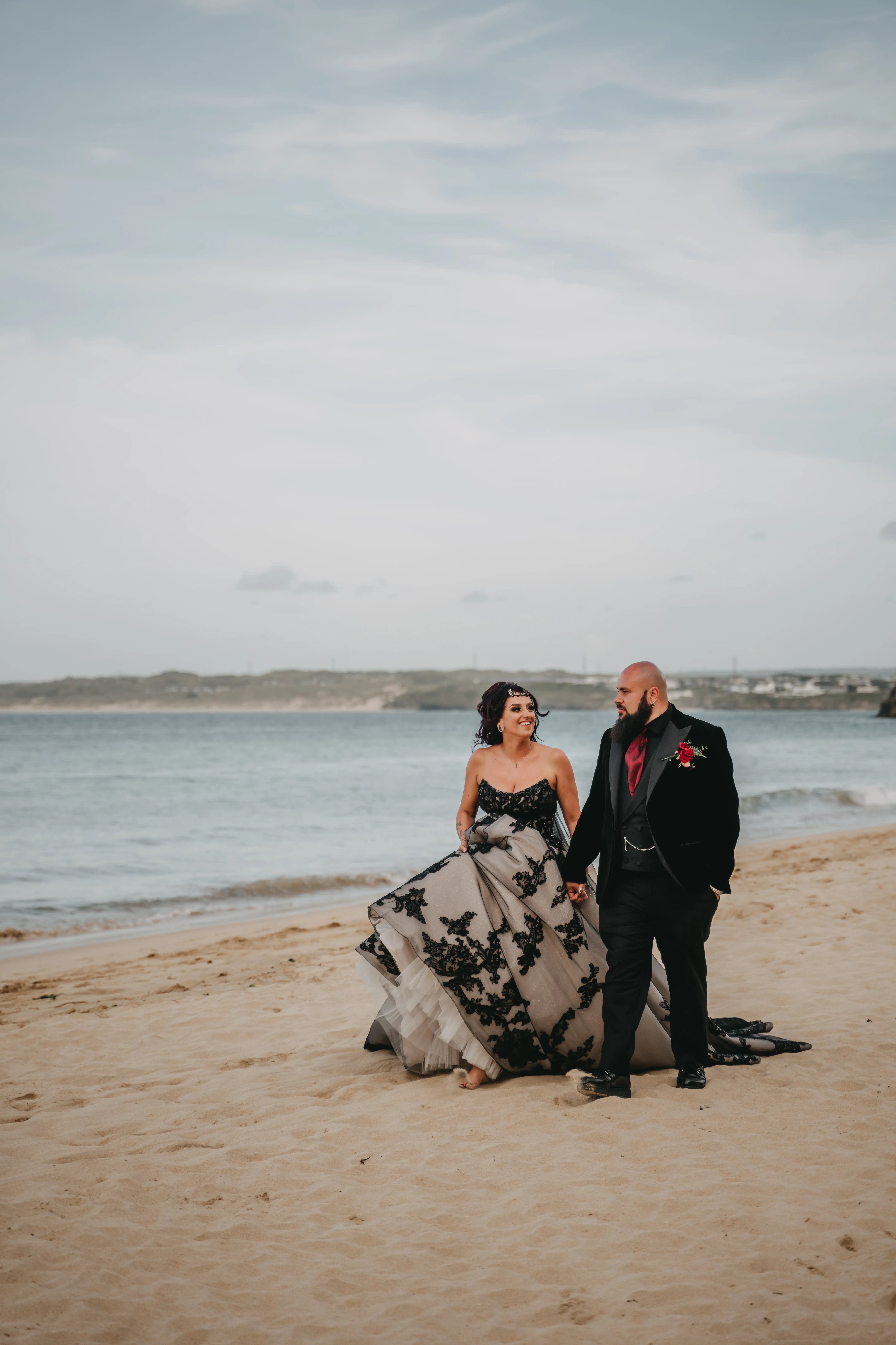 Bride wearing Norvinia by Sottero and Midgley on the beach with her husband