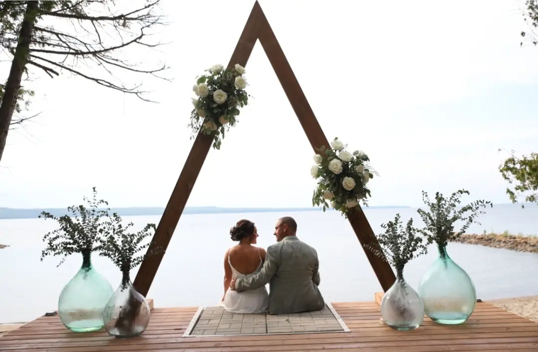 Bride Wearing Simple Chiffon Wedding Dress Called Marta Lynette By Rebecca Ingram With Groom Under Triangle Arch