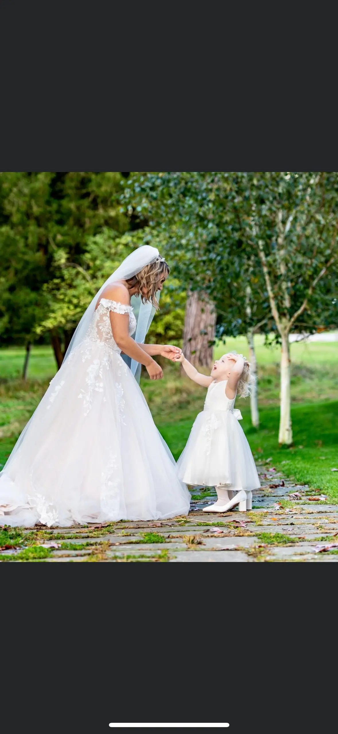 Bride wearing Harlem wedding dress by Maggie Sottero playing with little girl