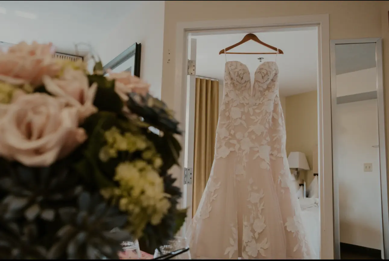 Floral Wedding Dress Named Hattie By Rebecca Ingram Hanging On A Hanger
