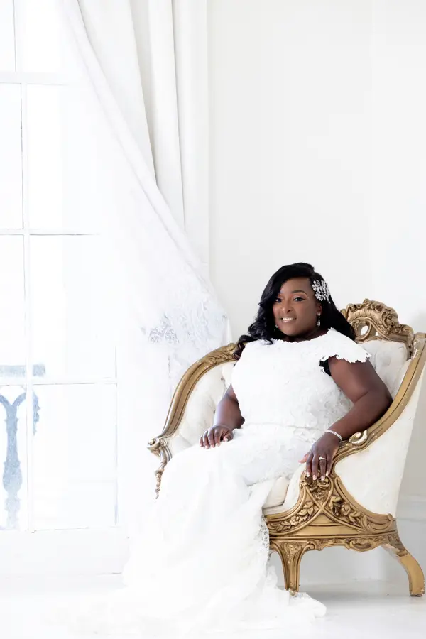 Bride wearing lace modest wedding dress with cap sleeves.