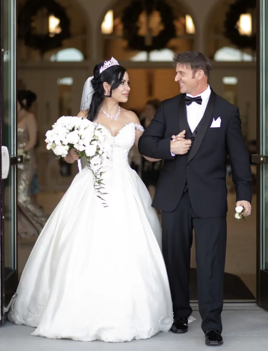 Bride wearing elegant satin ballgown called Kimora by Sottero and Midgley with groom