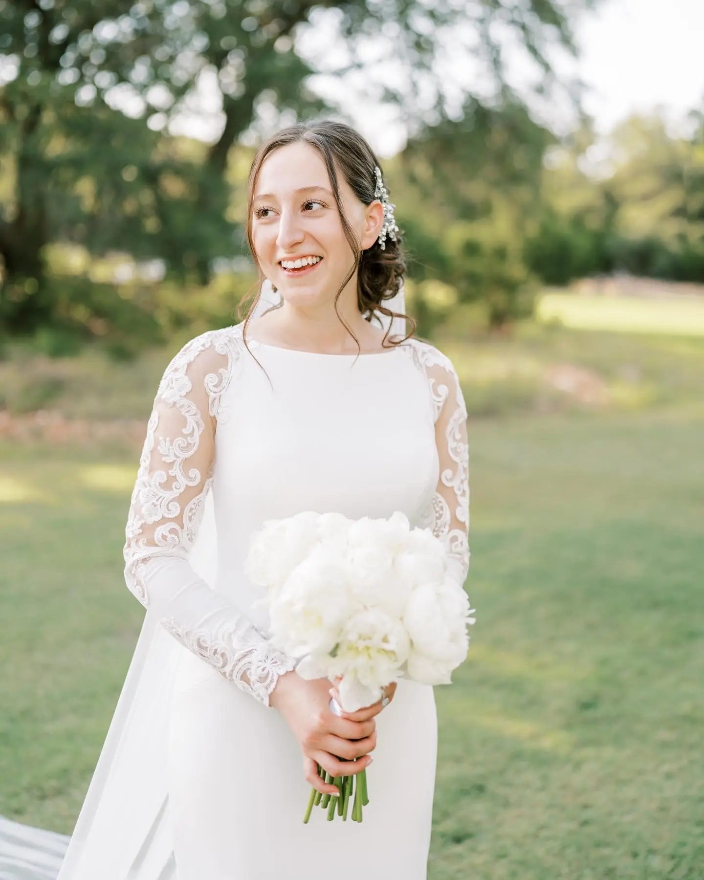 Bride Wearing Simple Long Sleeve Wedding Dress Called Bethany By Rebecca Ingram Holding A White Flower Bouquet