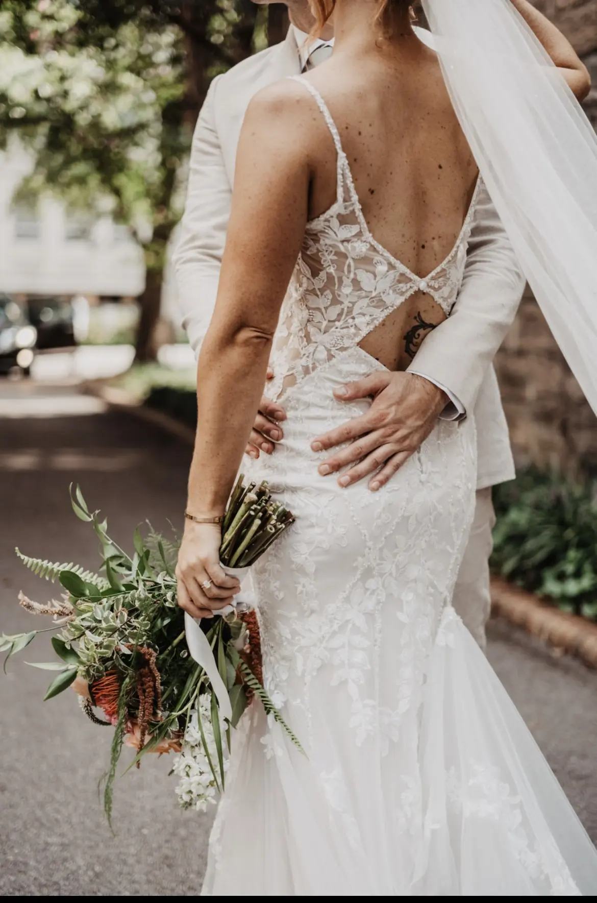 Bride wearing Sydney by Maggie Sottero being embraced by her husband