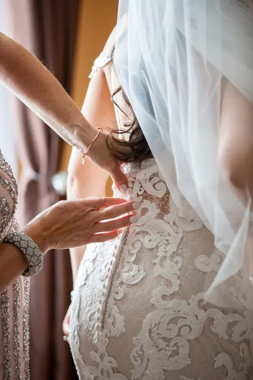 Buttoning Up Bride Wearing Lace Sheath Wedding Dress Called Tuscany Lynette By Maggie Sottero