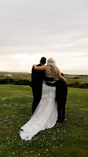 Back view of bride, groom and son looking at the sunset.