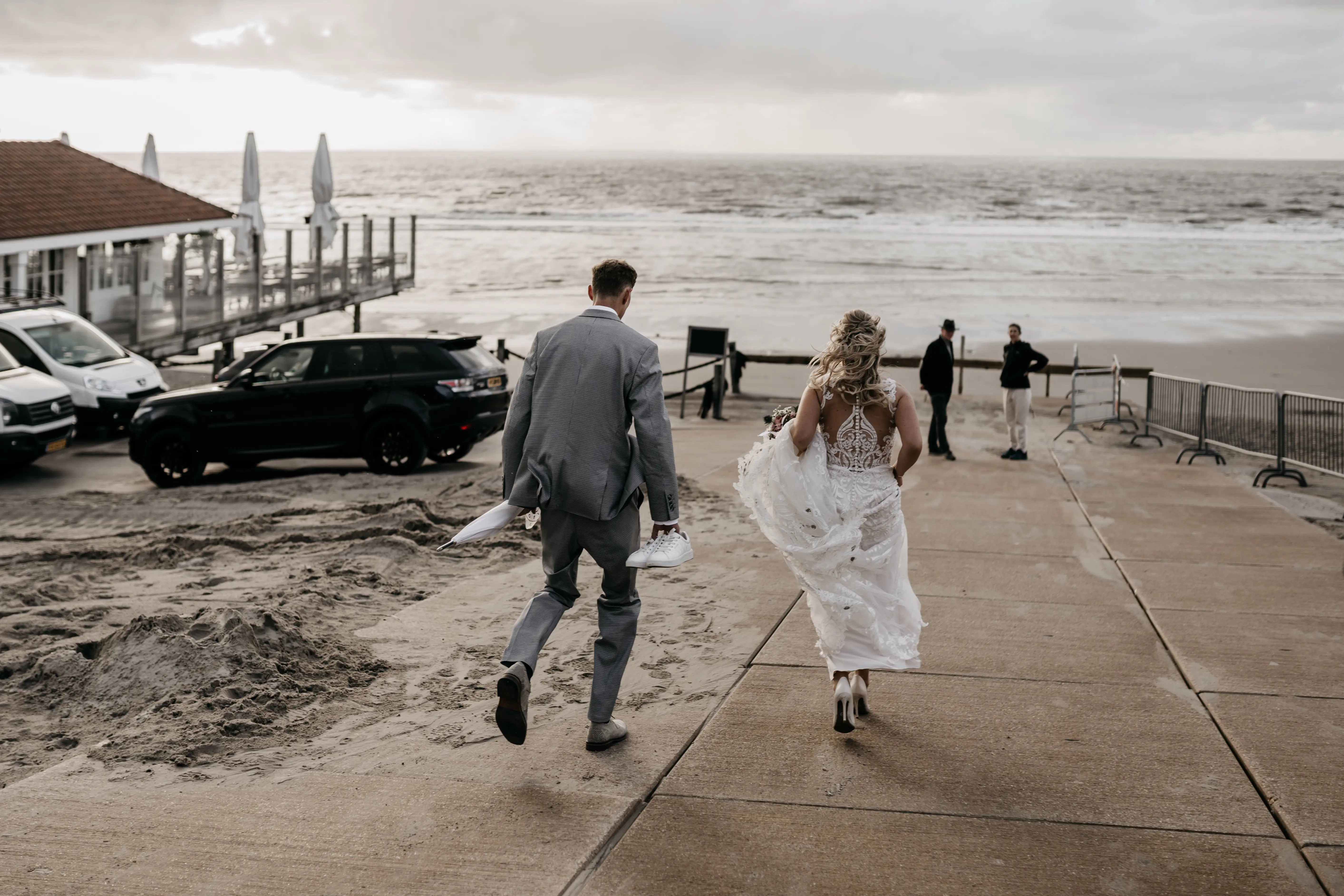 Bride Wearing Lace Fit-And-Flare Wedding Dress Called Hamilton By Sottero And Midgley Running To The Beach With Groom