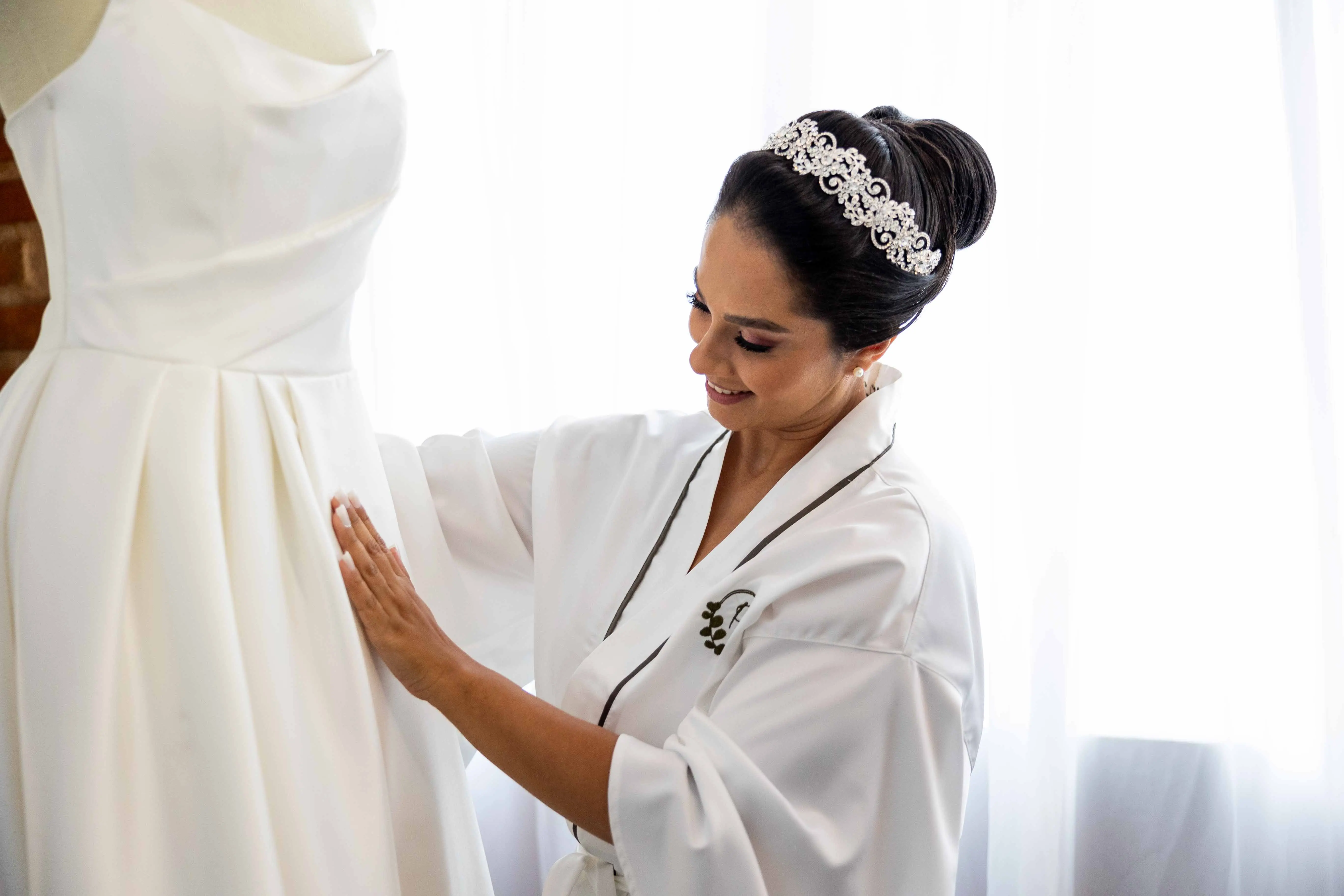 Bride looking at Aspen wedding dress by Sottero and Midgley