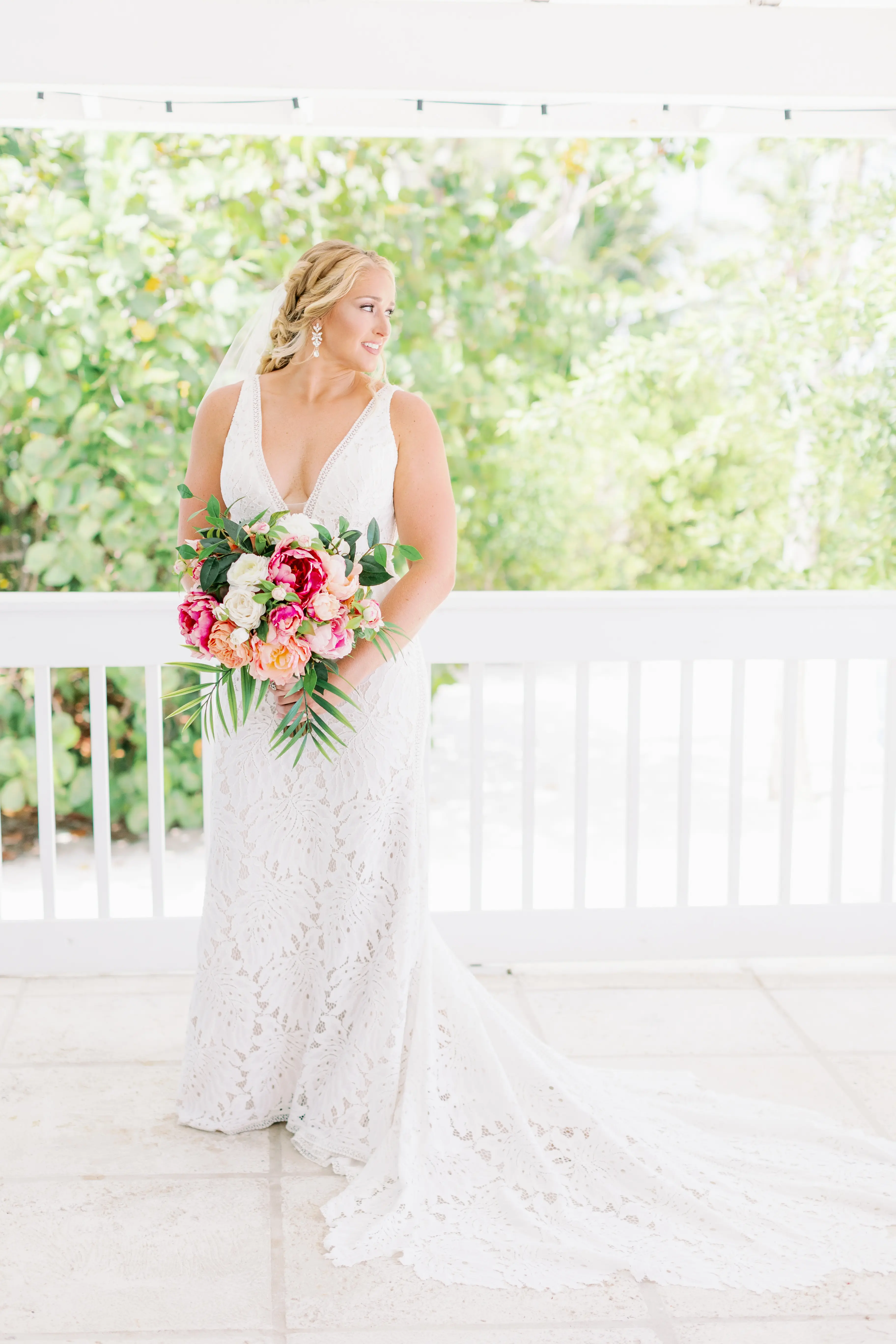 Bride with bright pink bouquet wearing wedding dress called Burke.