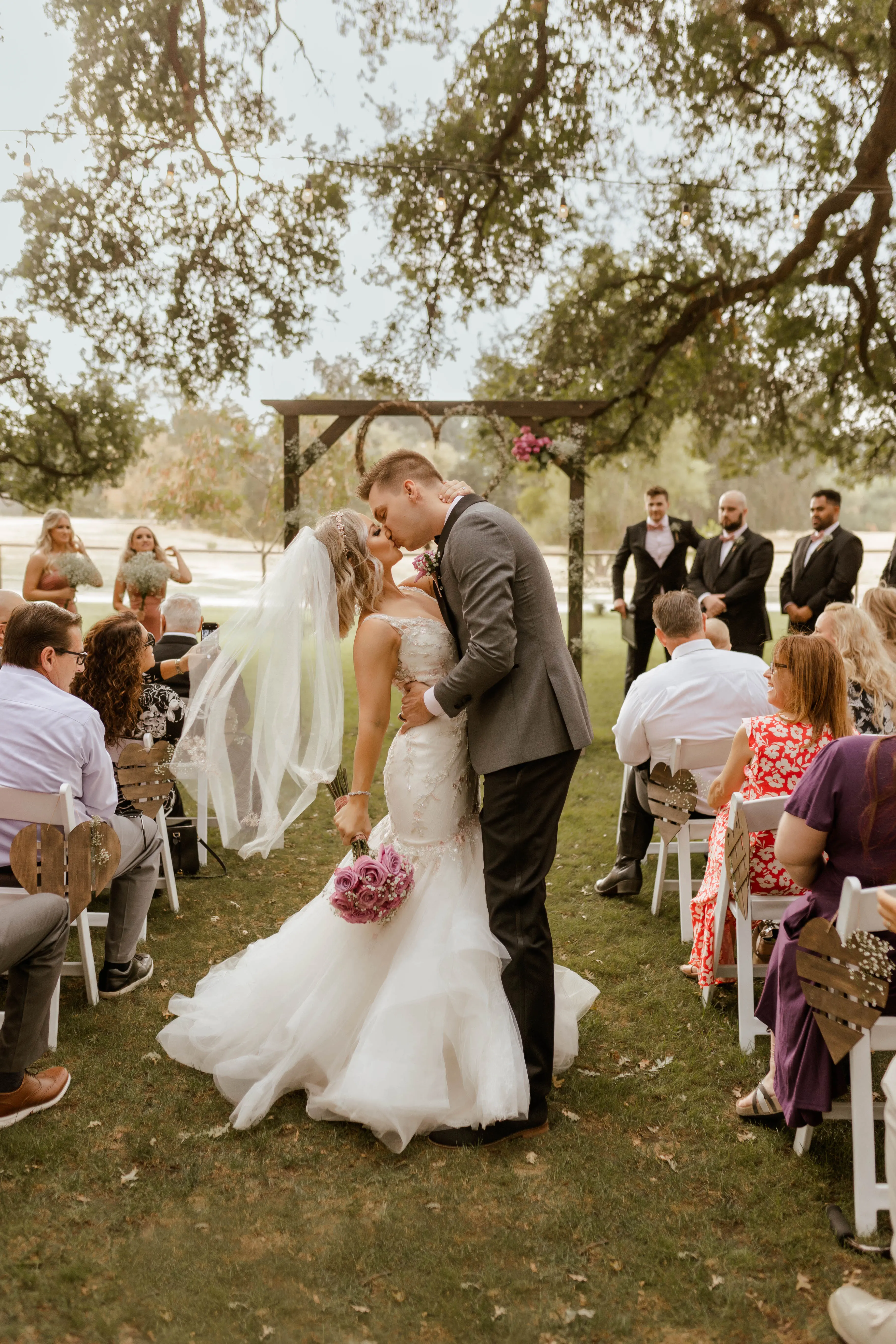 Bride Wearing Pink Lace Mermaid Wedding Dress Called Kenleigh By Sottero And Midgley Kissing Groom After The Ceremony