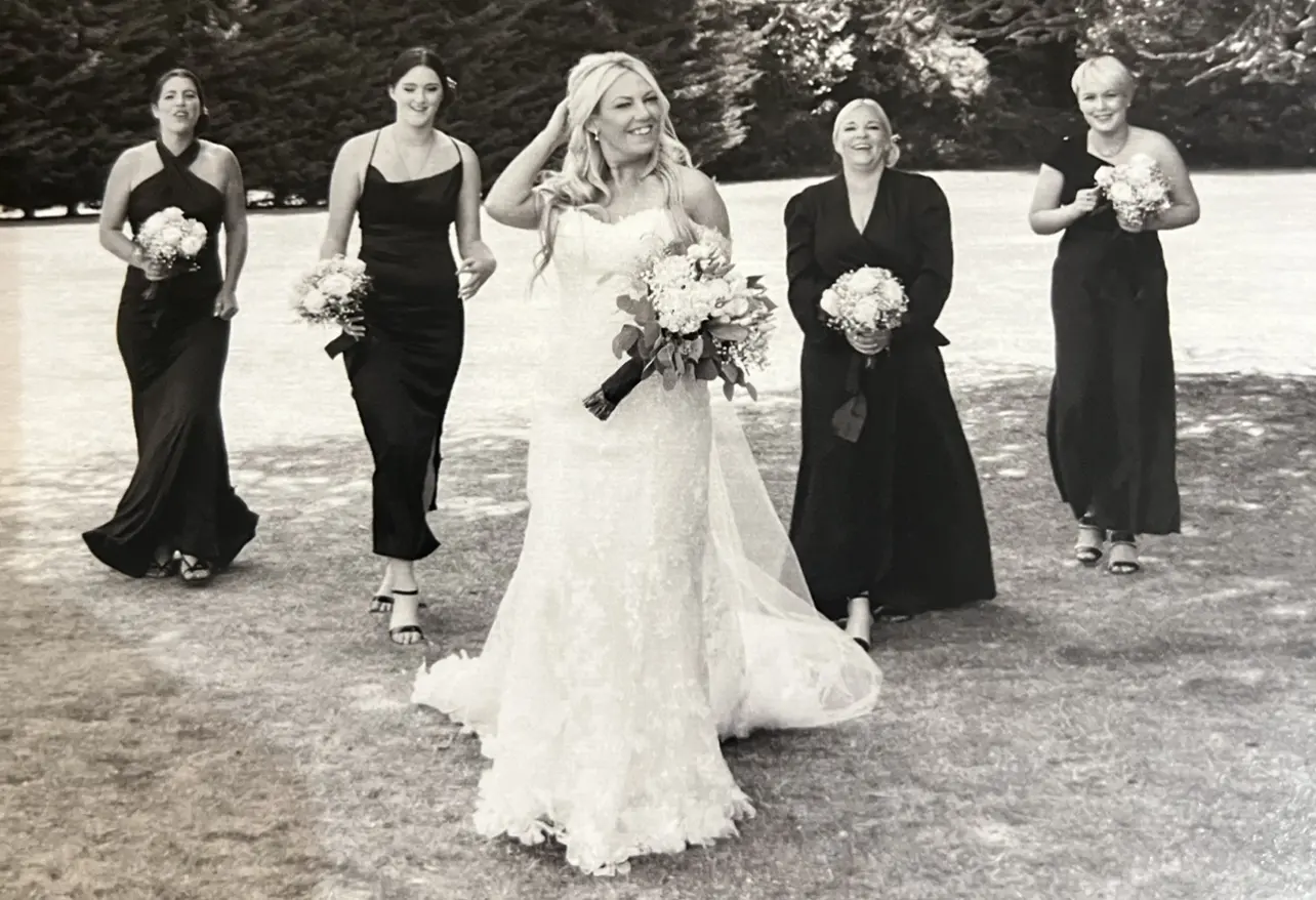 Bride Walking With Bridesmaids. Bride Wearing Fit And Flare Lace Wedding Dress With 3D Floral Details Called Ryker By Sottero And Midgley