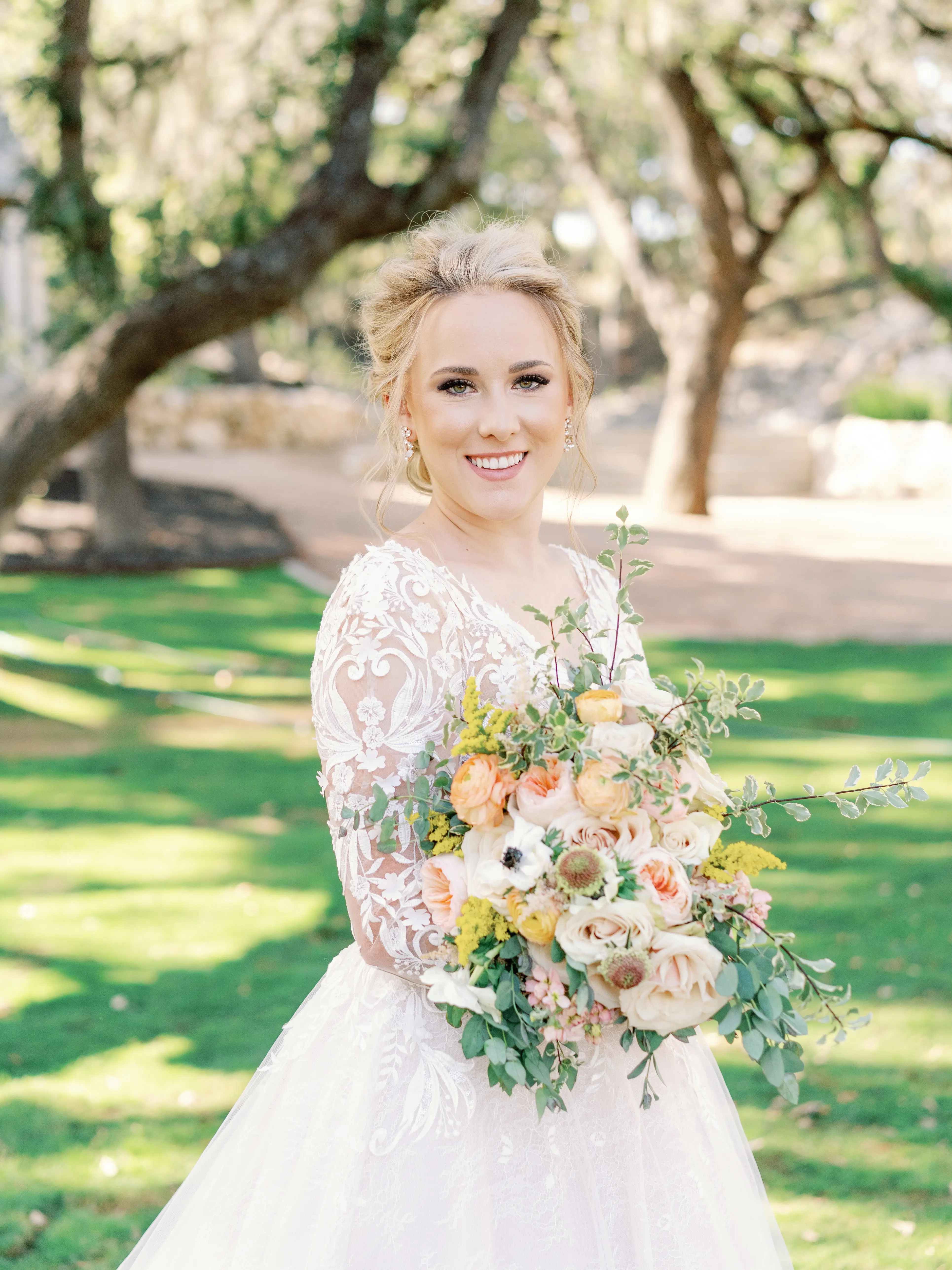 Real Bride Wearing Lace Ballgown Wedding Dress Called Zander By Sottero and Midgley Holding a Yellow Orange and White Bouquet
