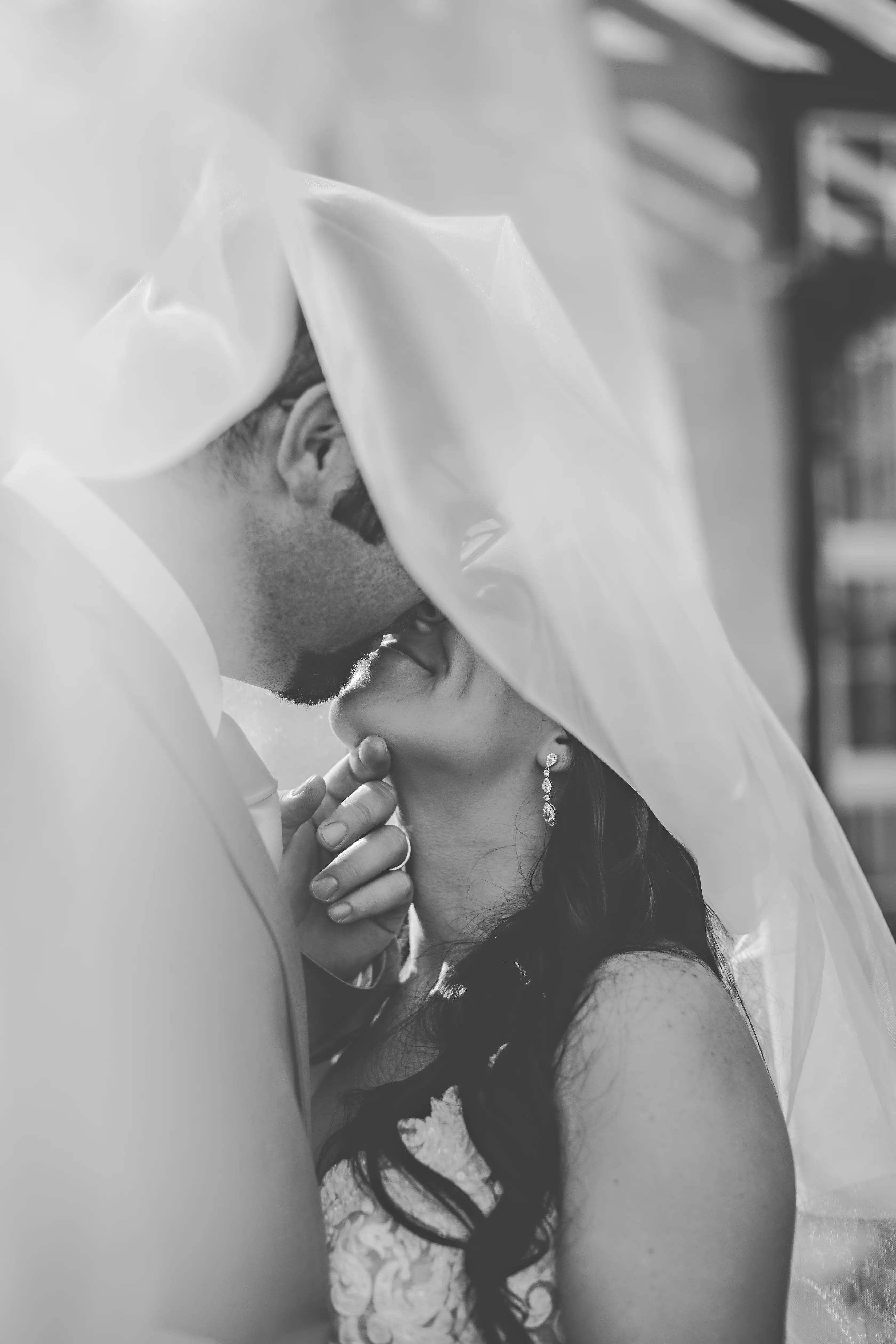 Groom Kissing Bride in Shimmering Lace Motif Wedding Gown with Plunging Sweetheart Neckline Called Tuscany Lynette by Maggie Sottero