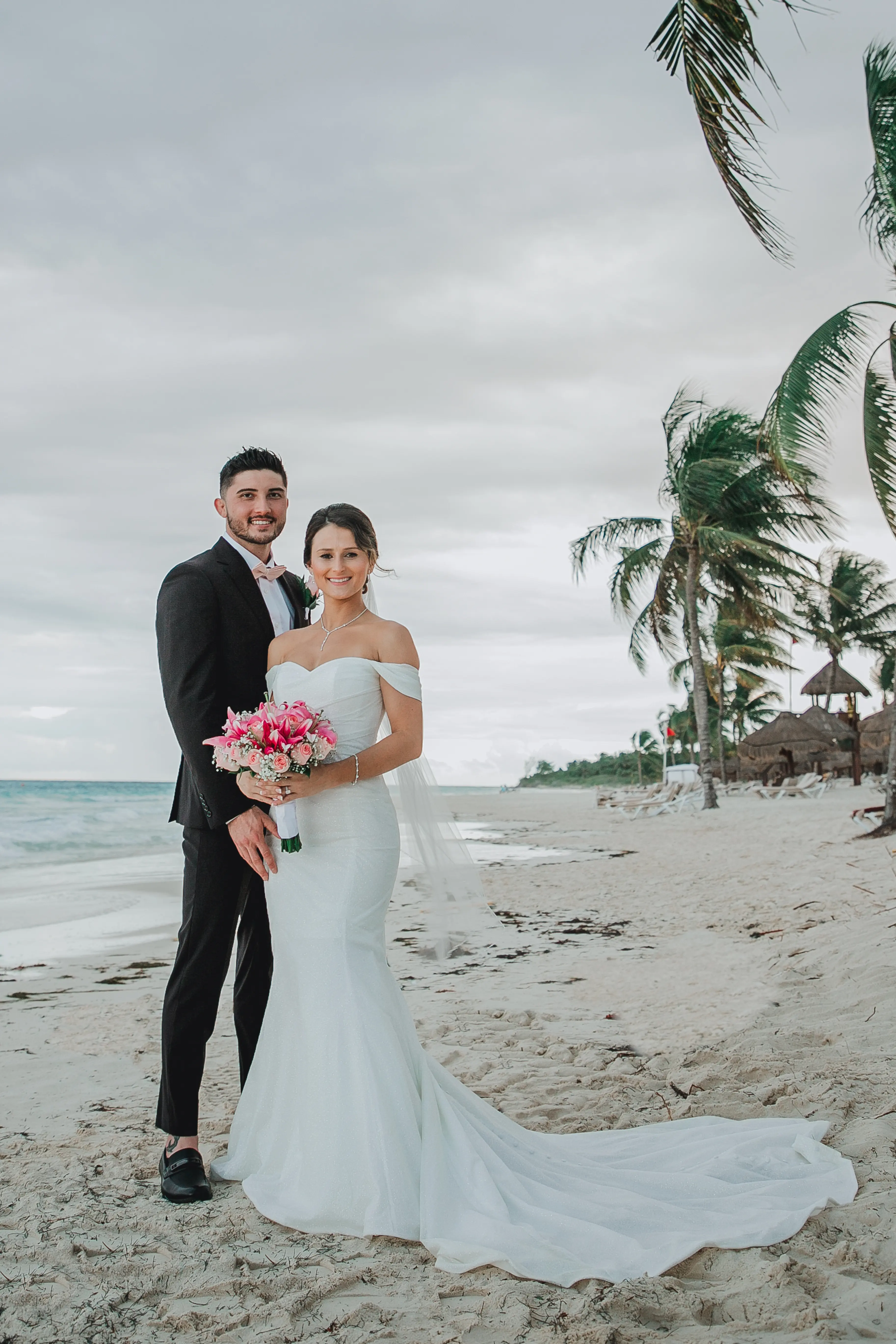 Bride Wearing Sparkly Fit And Flare Wedding Dress Called Anniston Lane By Maggie Sottero With Groom On The Beach