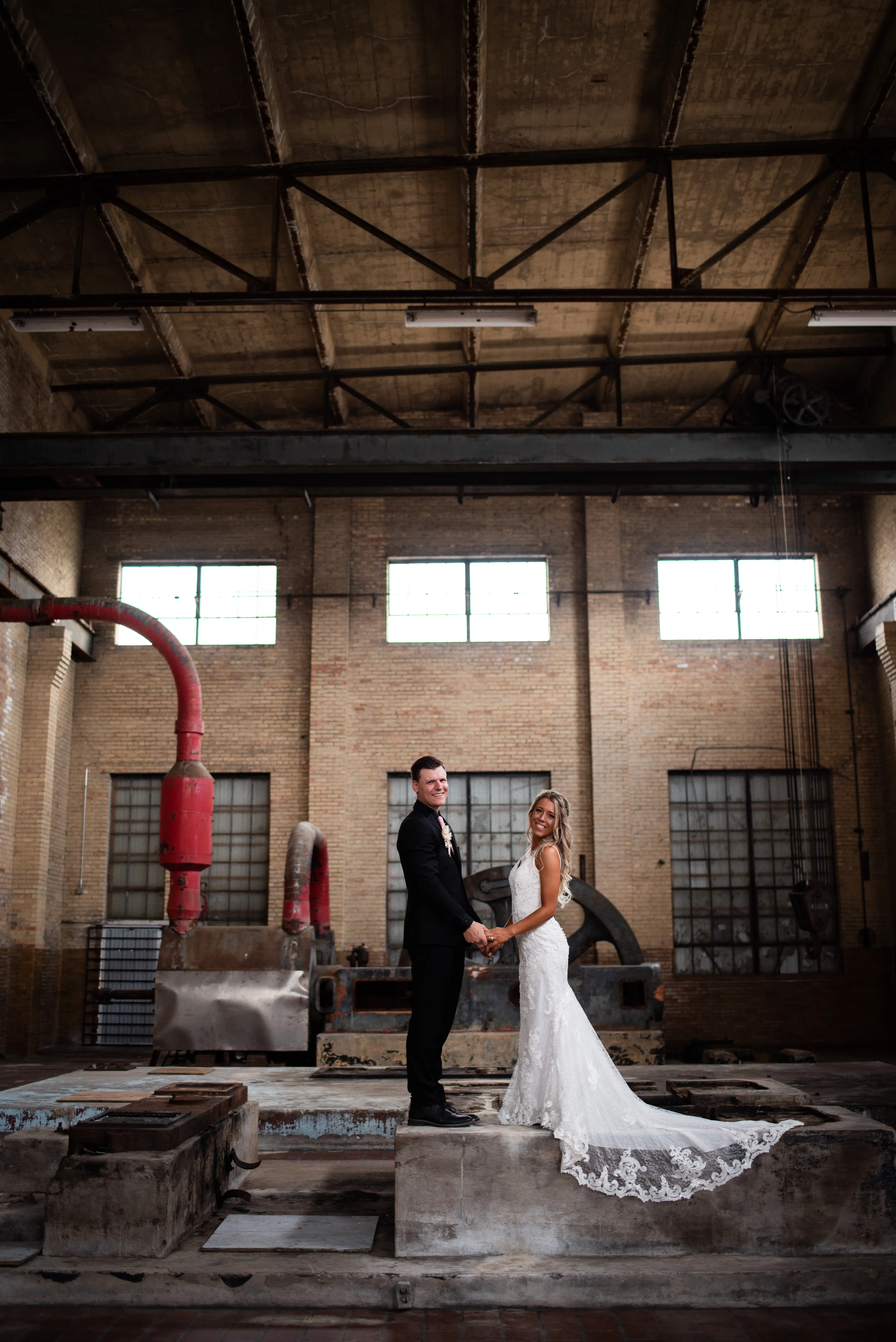 Bride with groom wearing romantic lace sheath wedding dress.