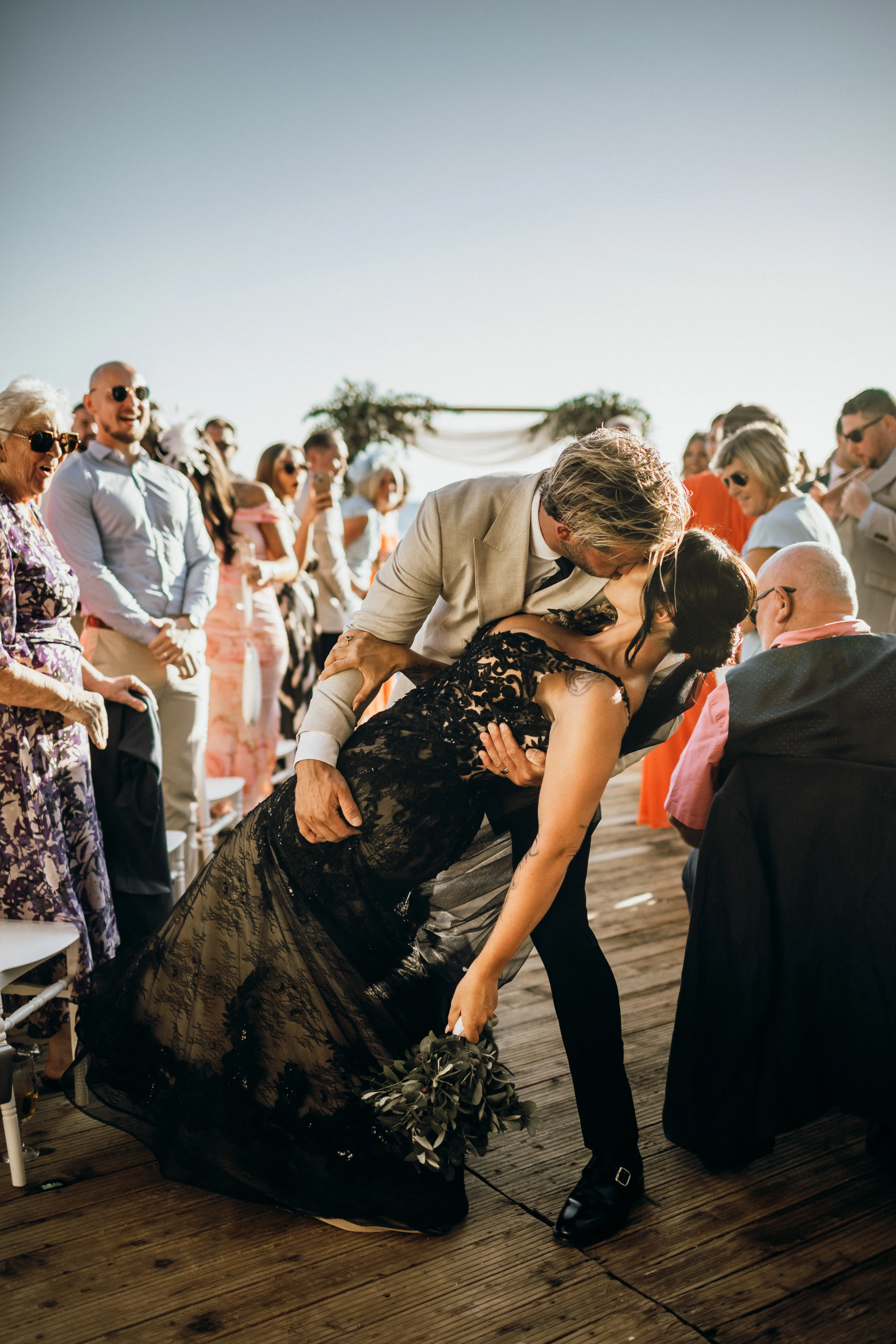 Bride Wearing Black Fit And Flare Wedding Dress Called Zander Lane By Sottero And Midgley Kissing Groom After The Ceremony