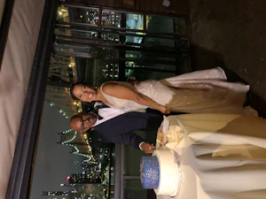 Bride And Groom Cutting The Cake With City Skyline Backdrop. Bride Wearing Dazzling Beaded Art Deco Gown Called Elaine By Maggie Sottero