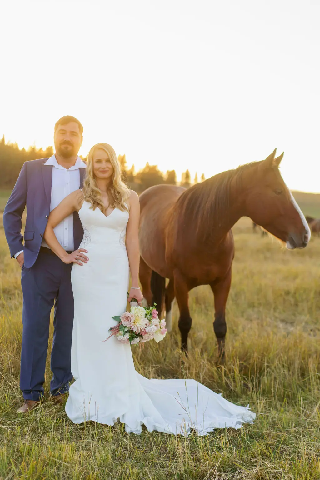 Bride wearing Dionne wedding dress by Rebecca Ingram with her husband in front of a horse