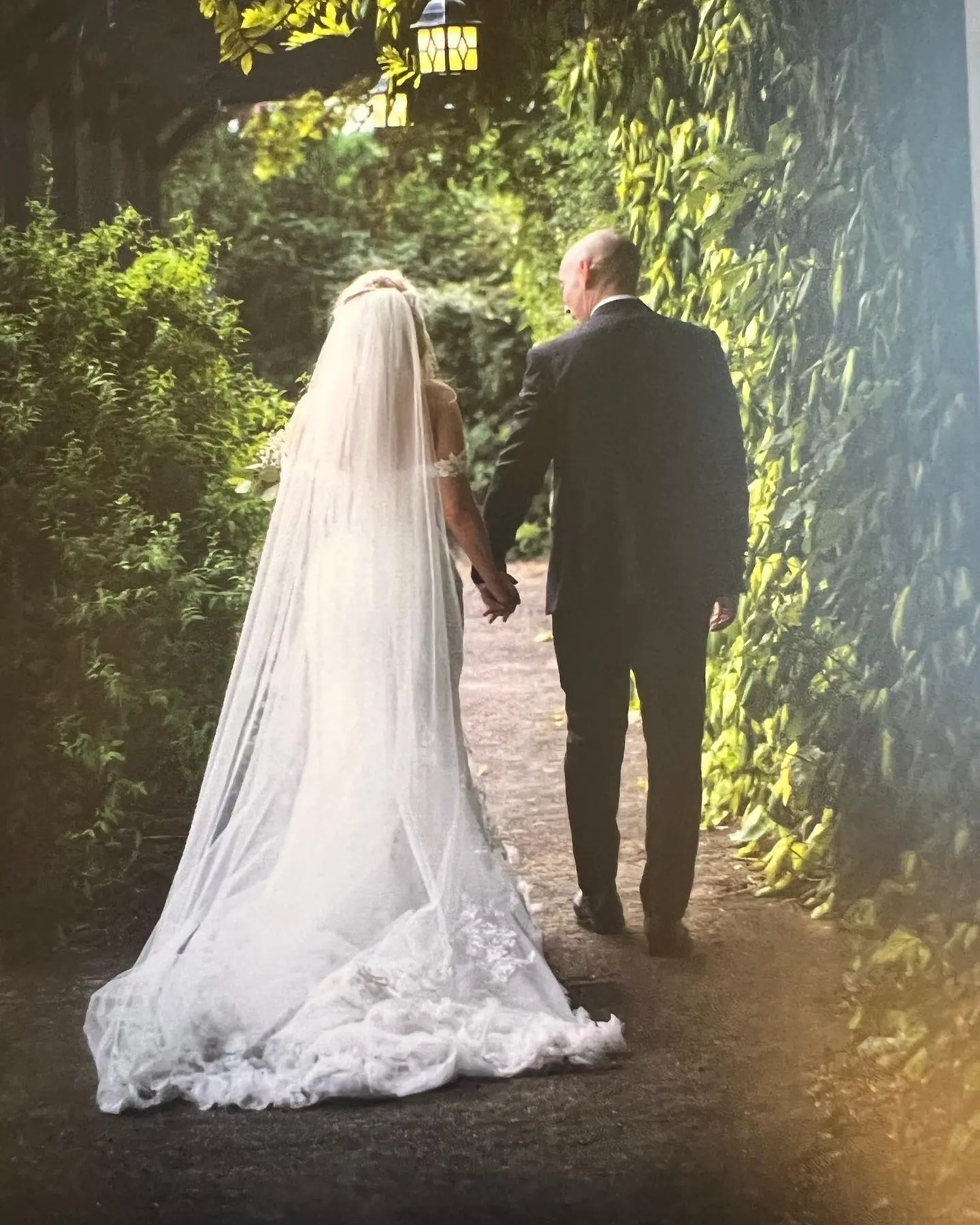 Bride And Groom Walking Together. Bride Wearing Fit And Flare Lace Wedding Dress With 3D Floral Details Called Ryker By Sottero And Midgley