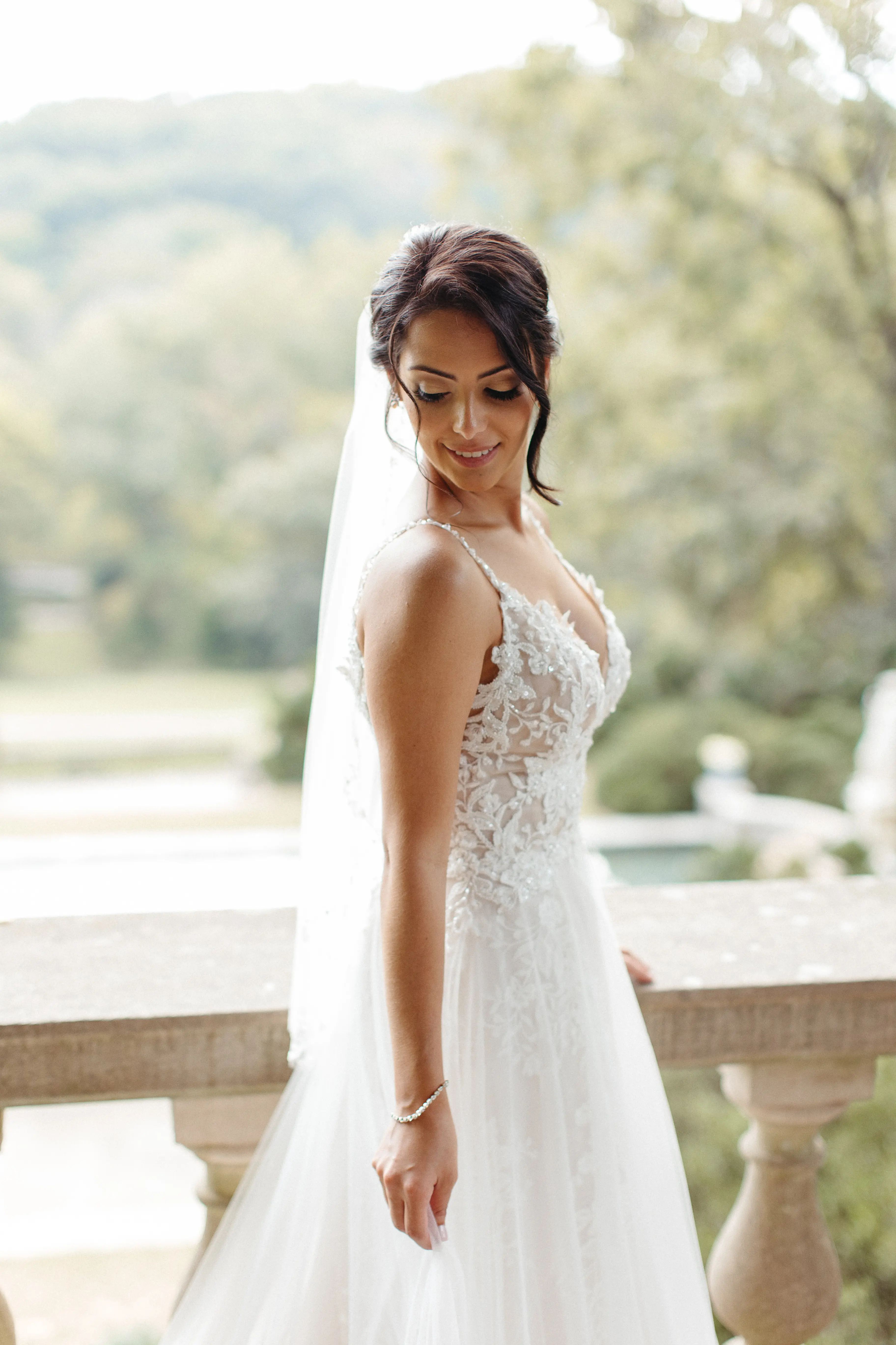 Bride looking over her shoulder wearing wedding dress called Roanne Rose.