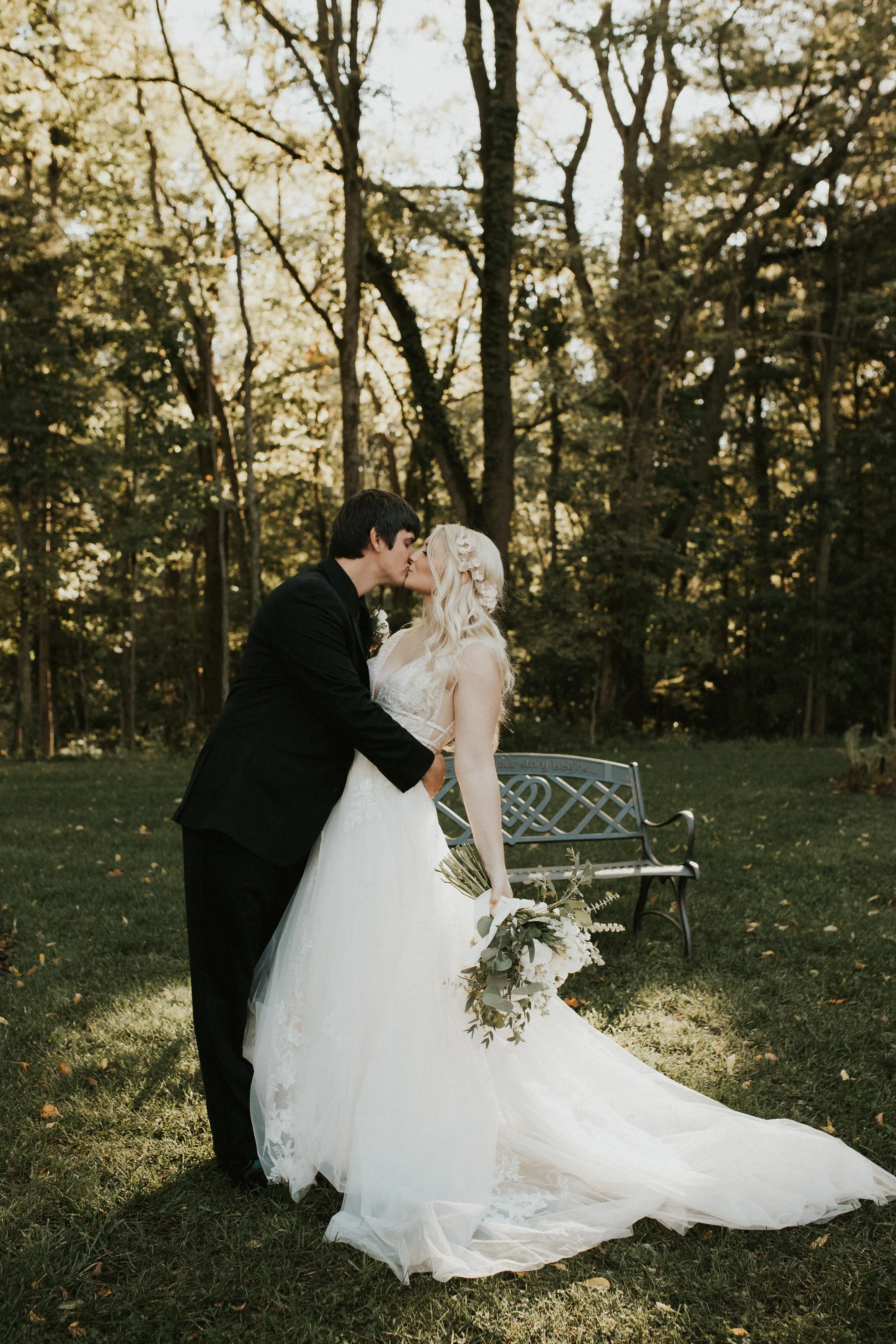 Bride Kissing Groom Wearing Bridal Gown Called Raelynn by Rebecca Ingram
