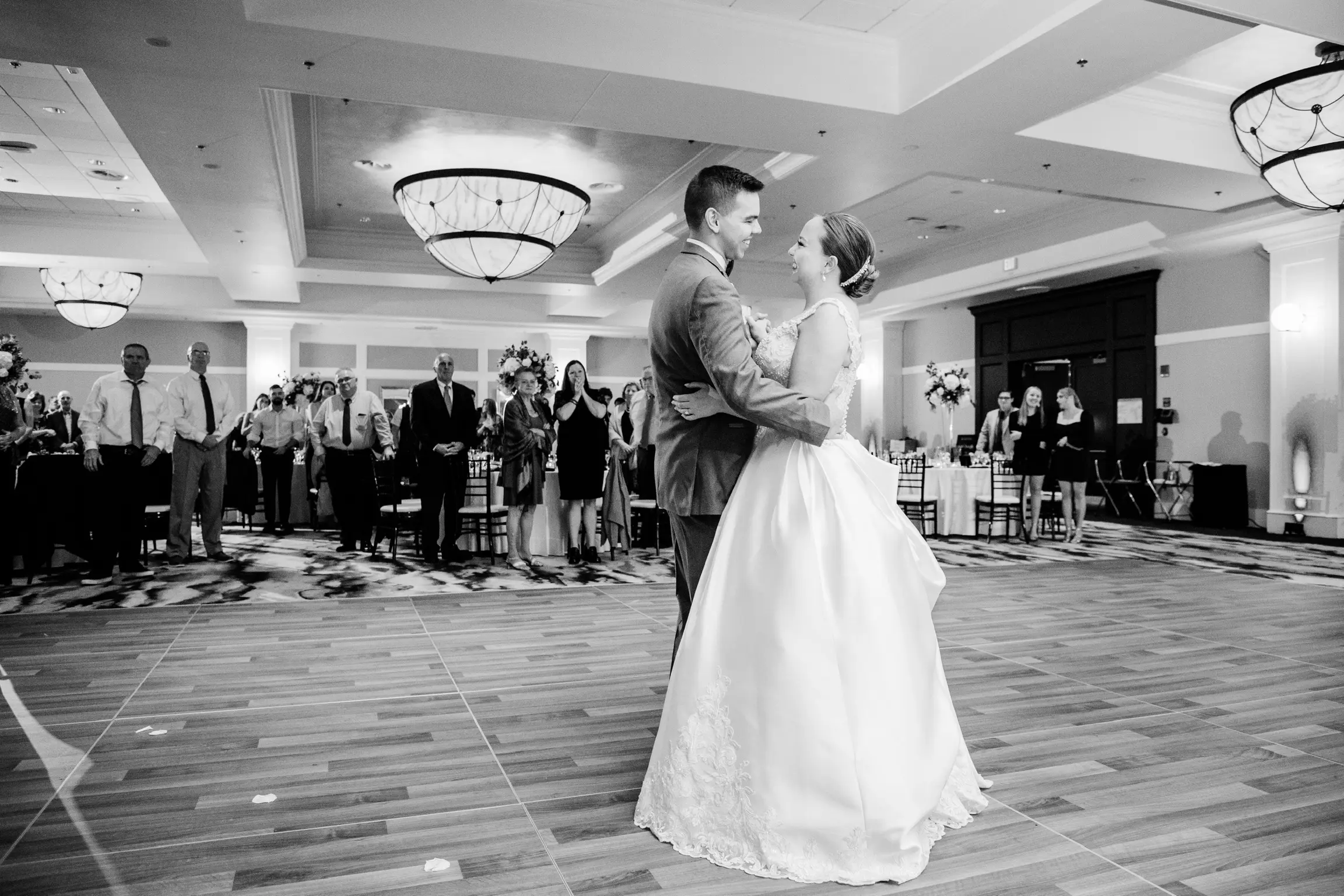 Bride And Groom Dancing. Bride Wearing Off-The-Shoulder Glamorous Ball Gown Called Kimora By Sottero And Midgley