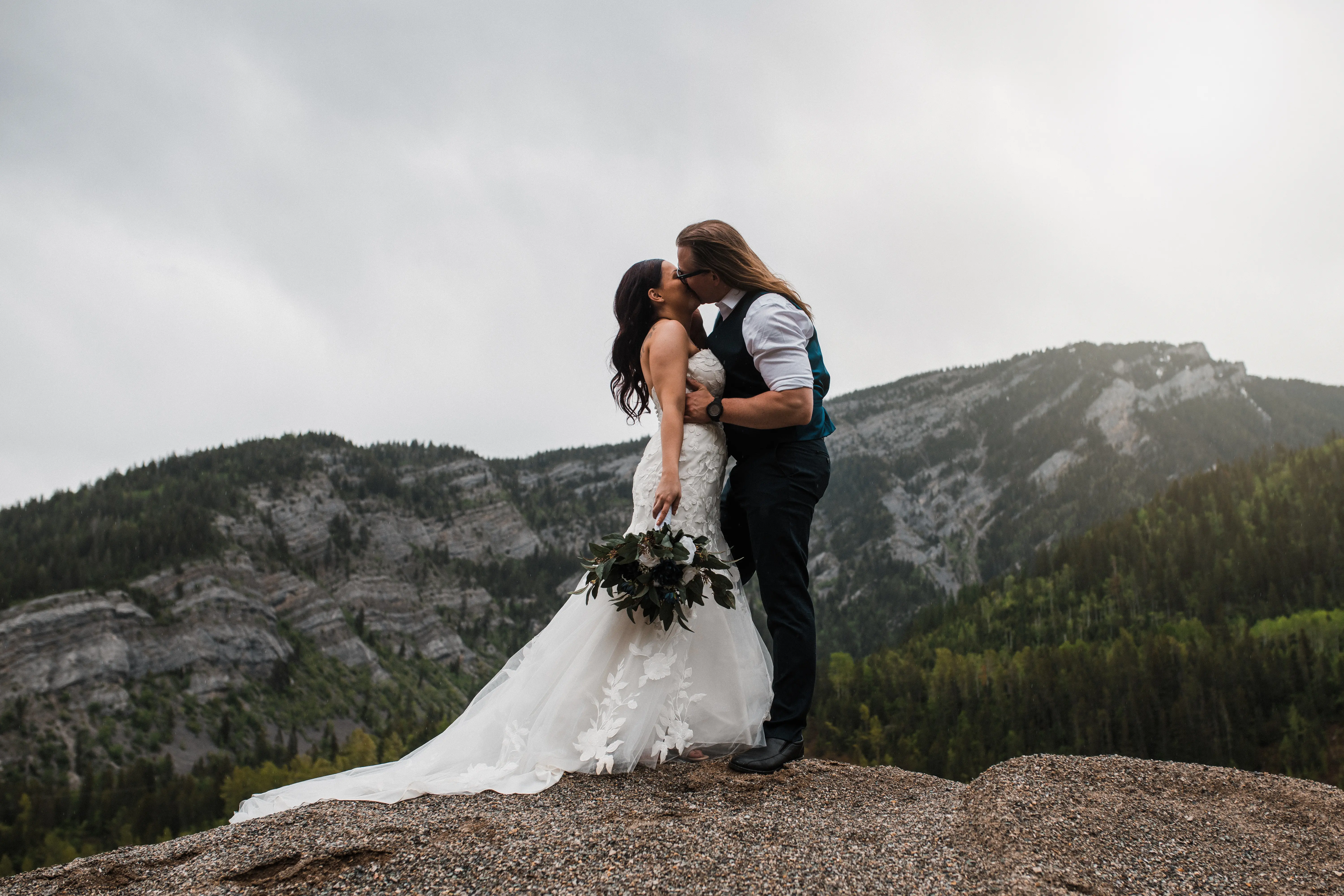 Groom On Mountain Kissing Bride In Strapless Mermaid Wedding Dress Called Hattie By Rebecca Ingram