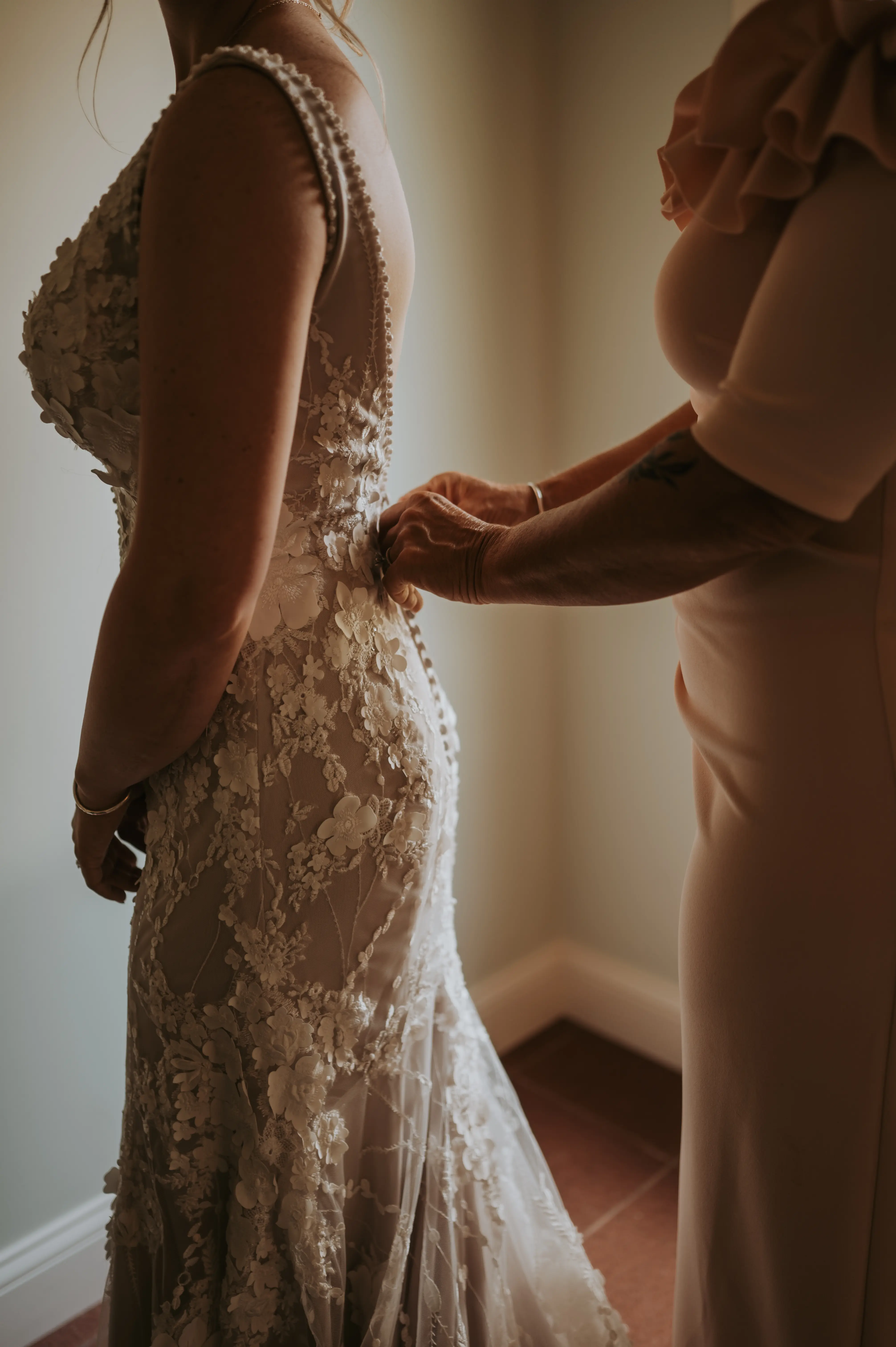Bride Getting Ready in Mermaid Wedding Dress with 3-D Floral Motifs and Extended Scalloped Lace Train Called Cruz by Sottero & Midgley