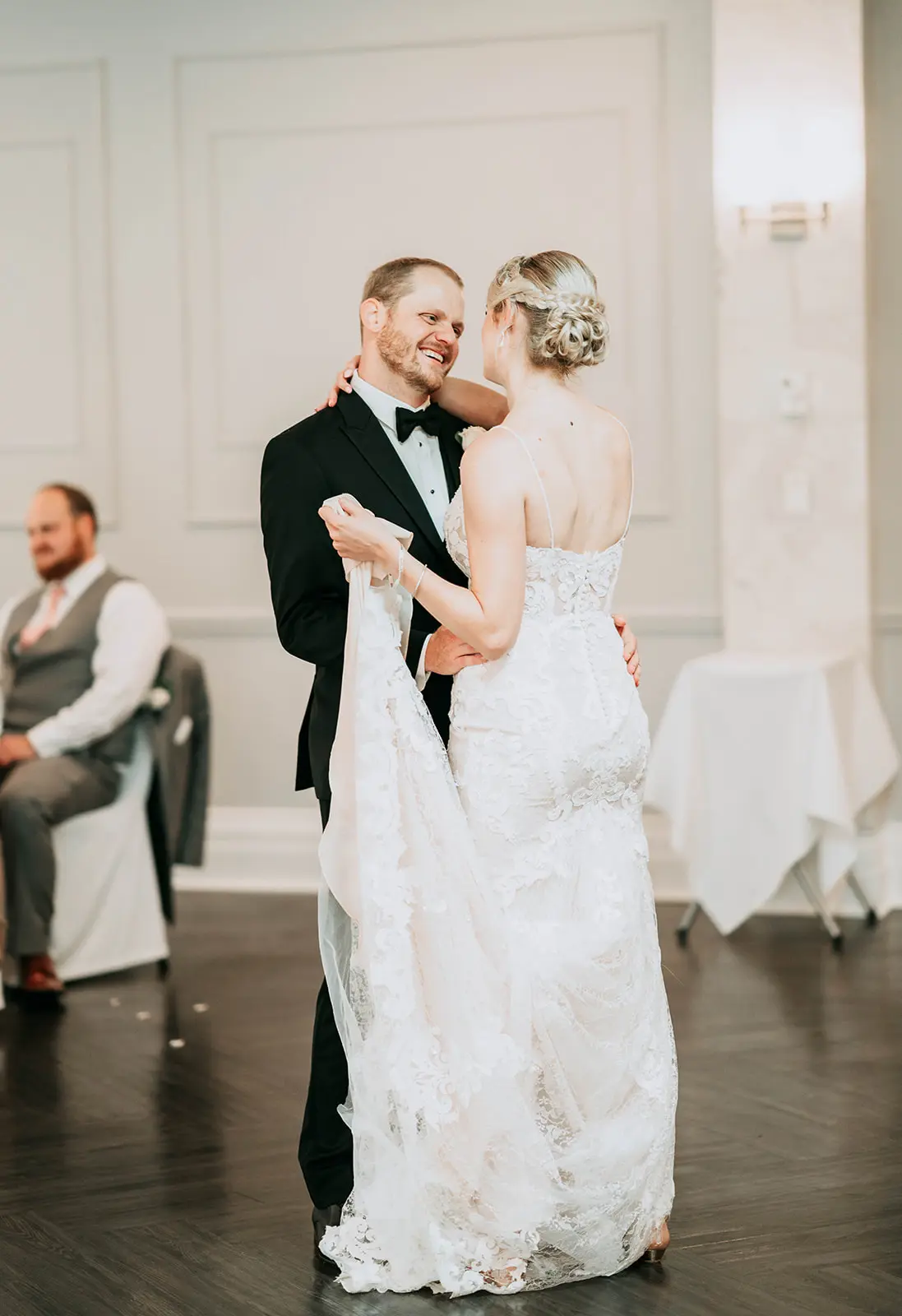 Groom smiling at his bride while slow dancing.