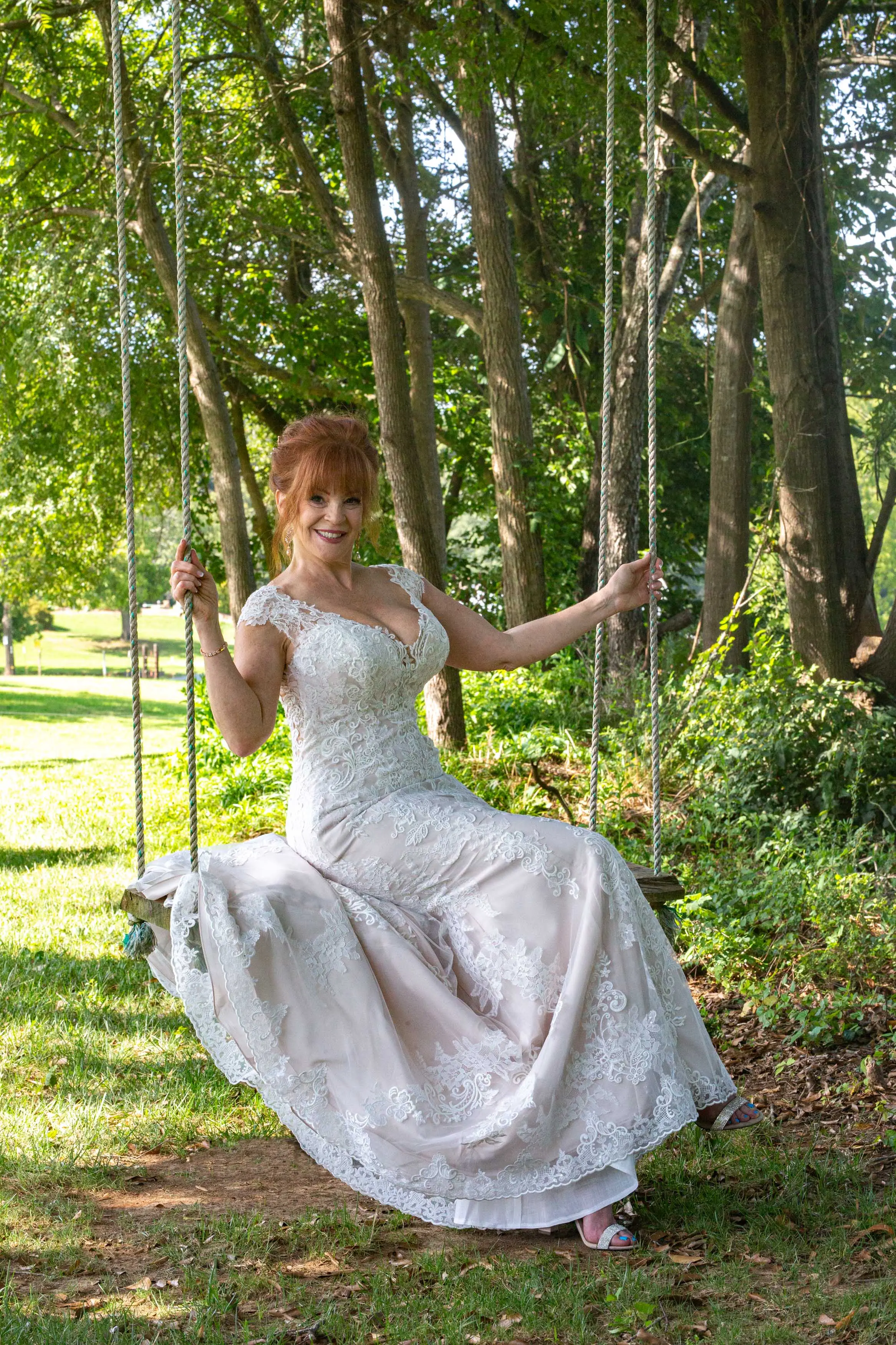 Bride on an Outdoor Swing Wearing a Lace Bridal Dress Called Daphne Lynette by Rebecca Ingram