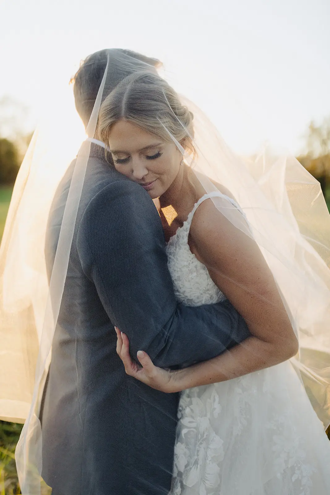 Groom Hugging Bride At Fall Wedding Wearing Ballgown Called Valona by Sottero and Midgley.