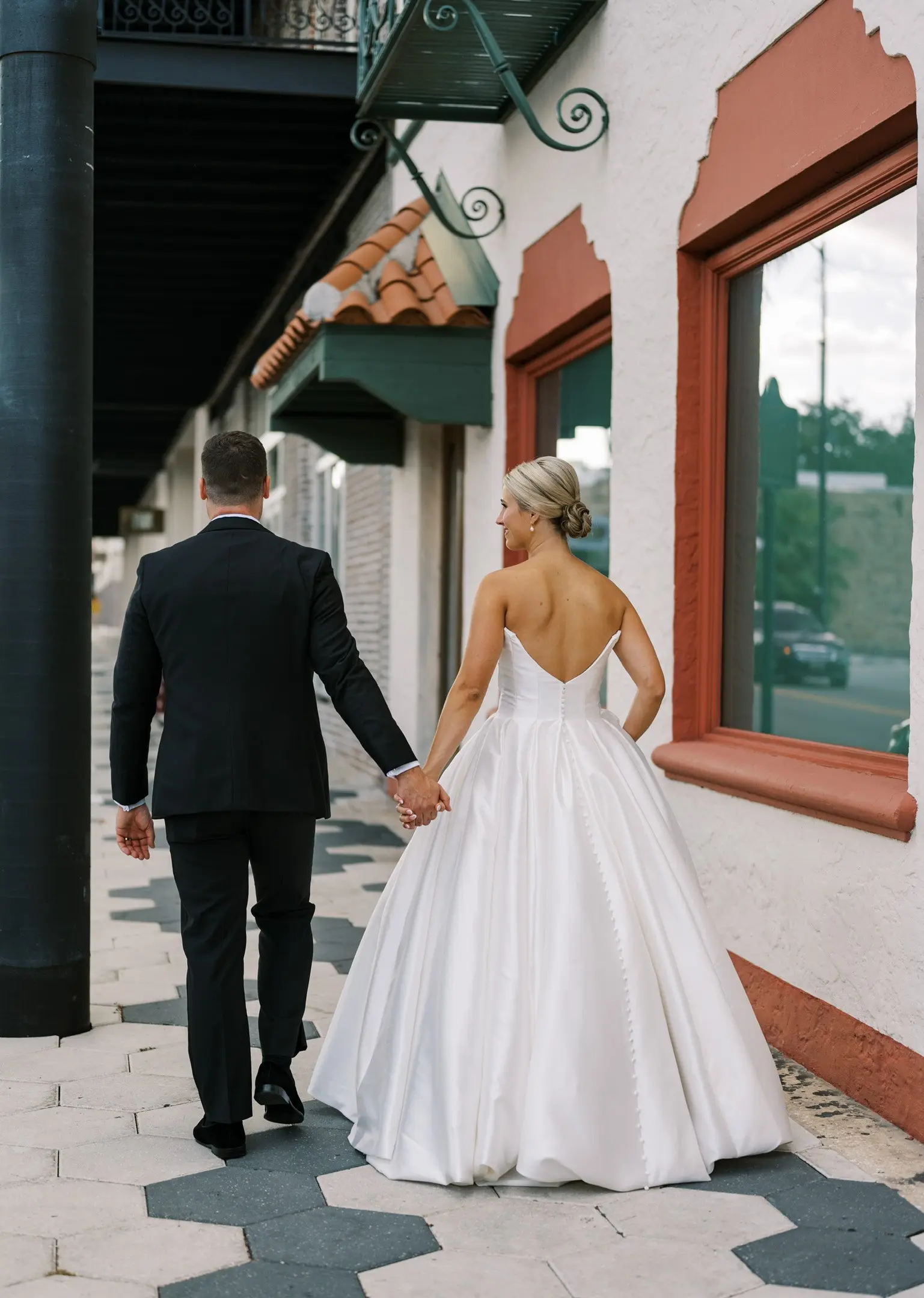 Bride wearing Zinaida by Maggie Sottero walking down the street with her husband