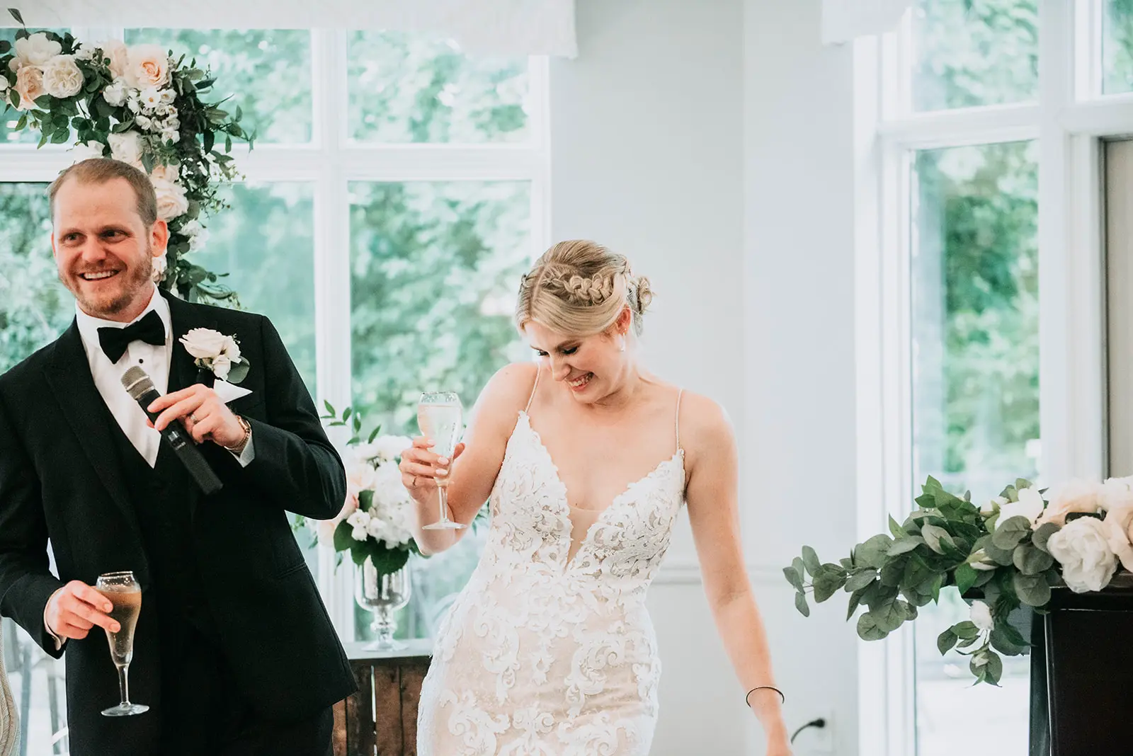 Bride and groom laughing at something funny during speeches.