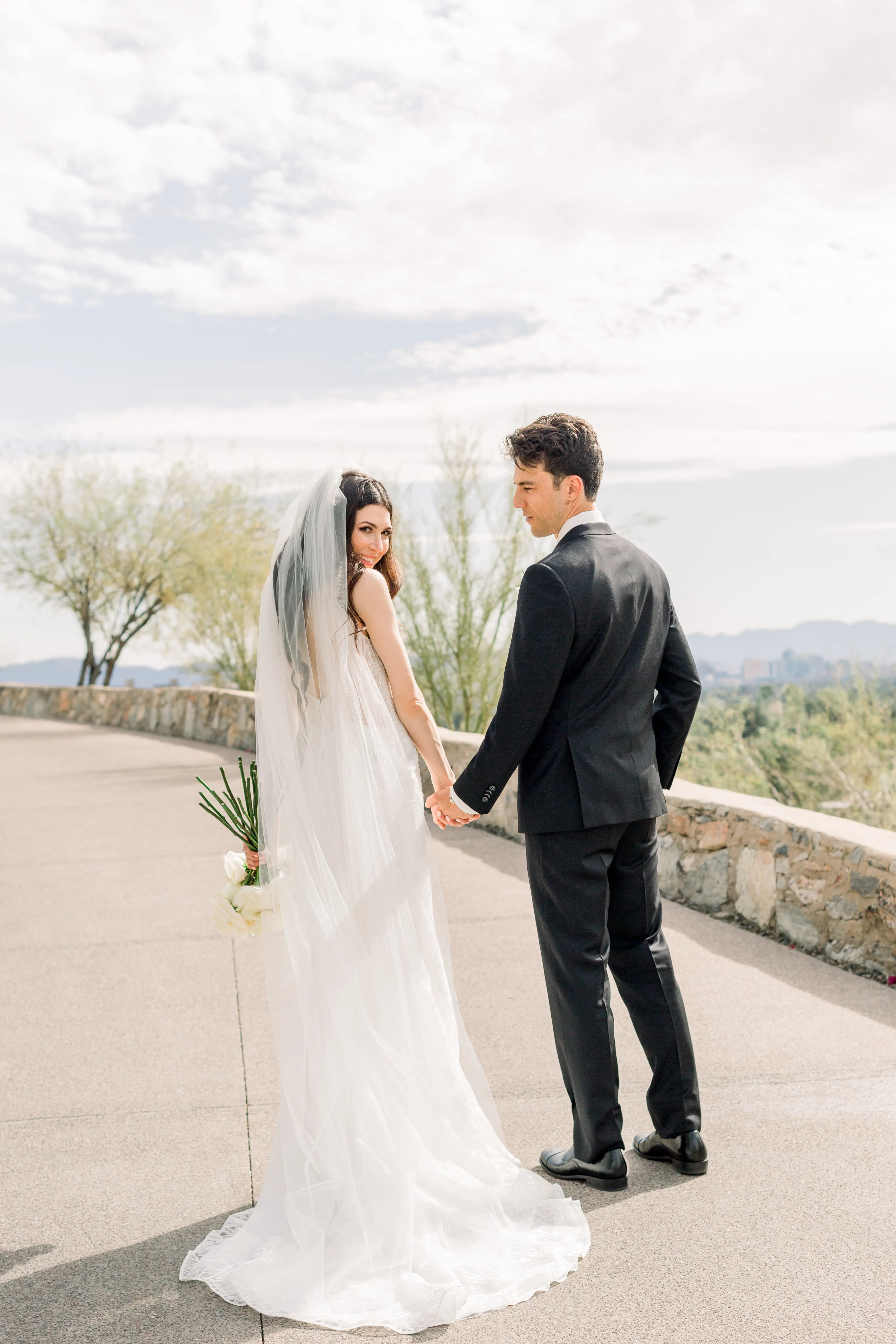 Bride Wearing Vintage Art Deco Wedding Dress Called Elaine By Maggie Sottero Holding Hands With Groom Looking Back