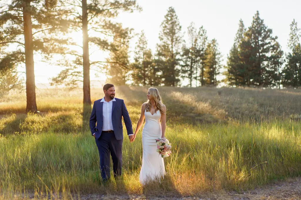Bride wearing Dionne wedding dress by Rebecca Ingram holding hands with her husband