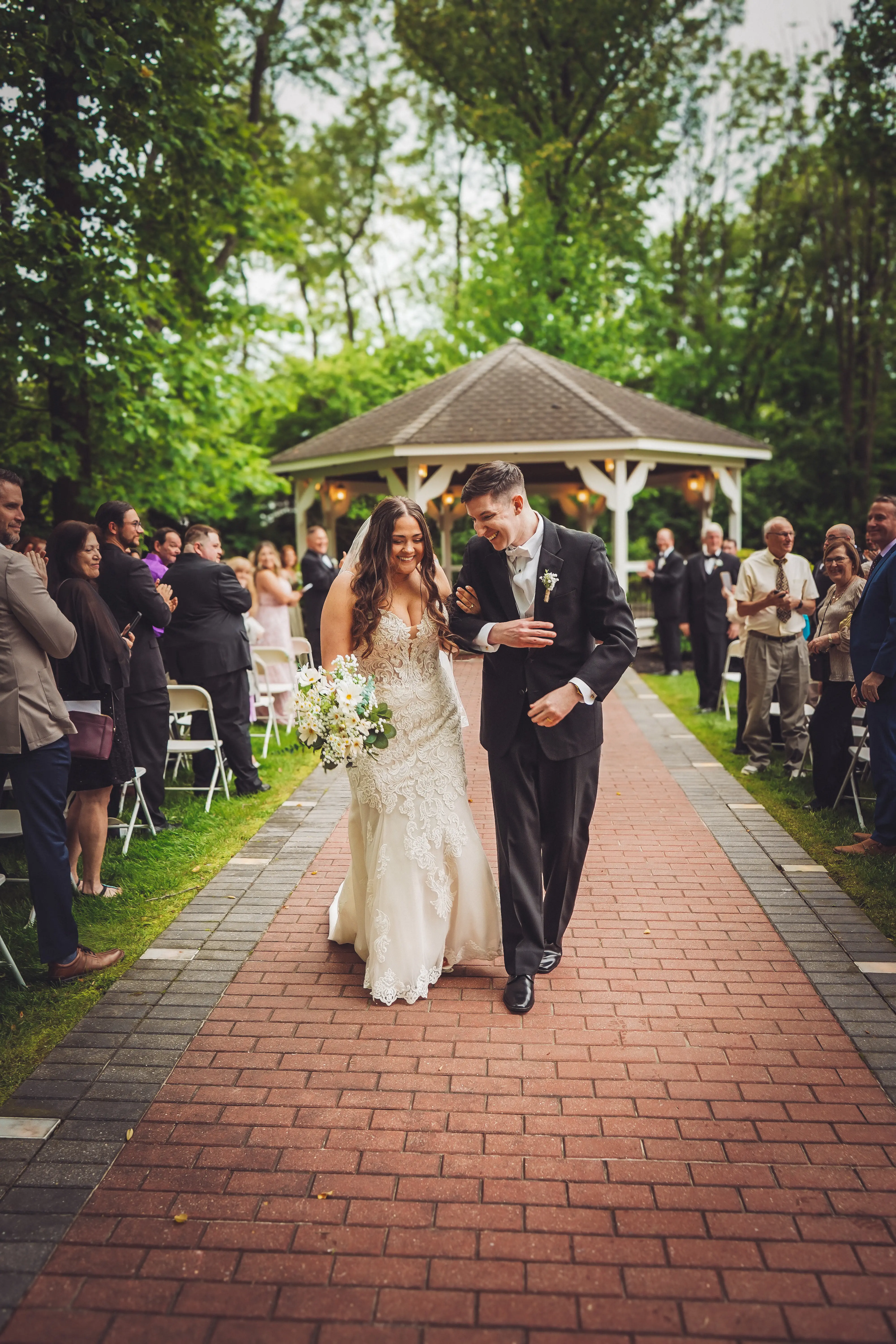 Bride wearing Fiona by Maggie Sottero walking with her husband from their ceremony
