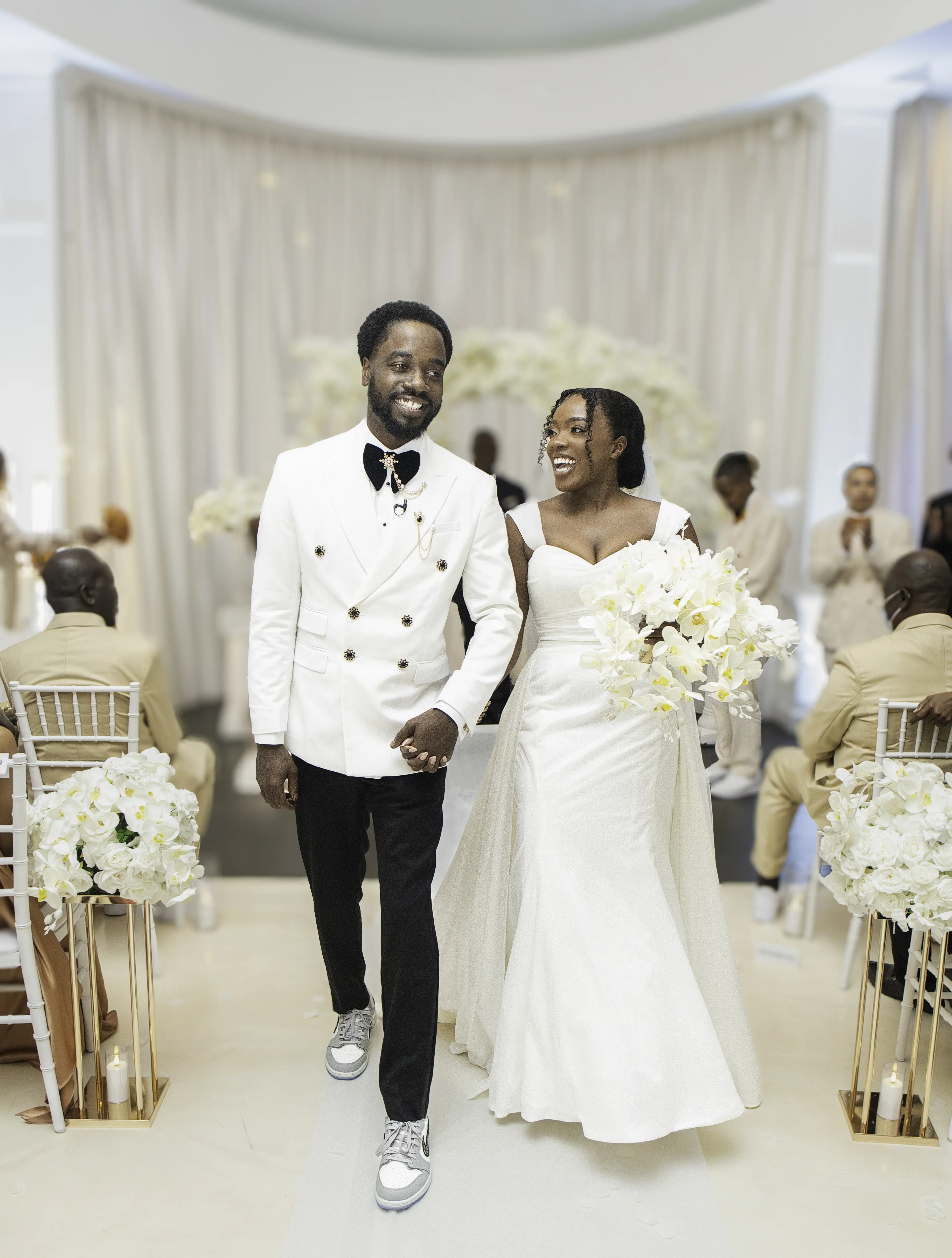 Bride Wearing Simple Fit and Flare Wedding Dress Called Anniston Lane Walking Hand In Hand With Groom