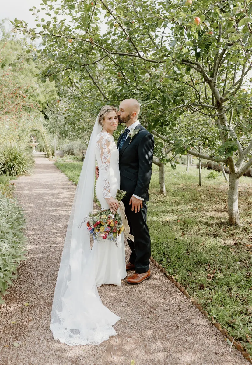 Bride wearing Bethany wedding dress by Rebecca Ingram being kissed by her husband