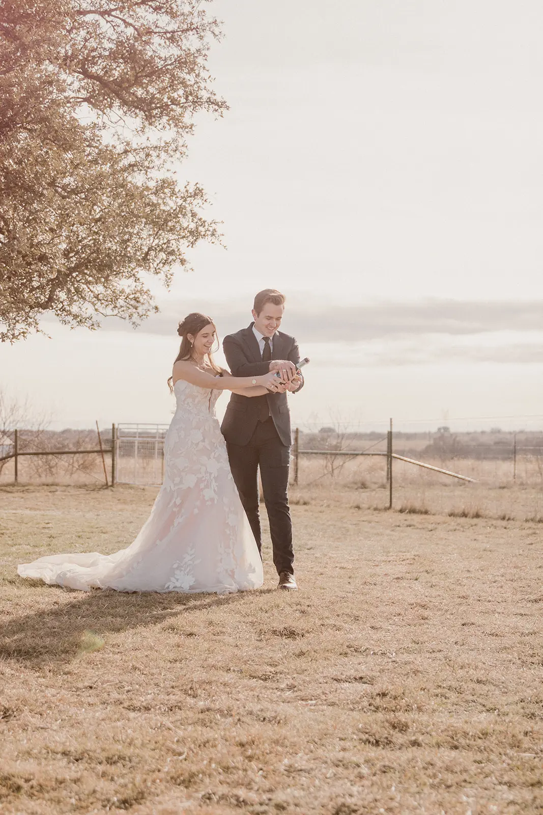 Bride wearing Bridget by Maggie Sottero opening a bottle with her husband