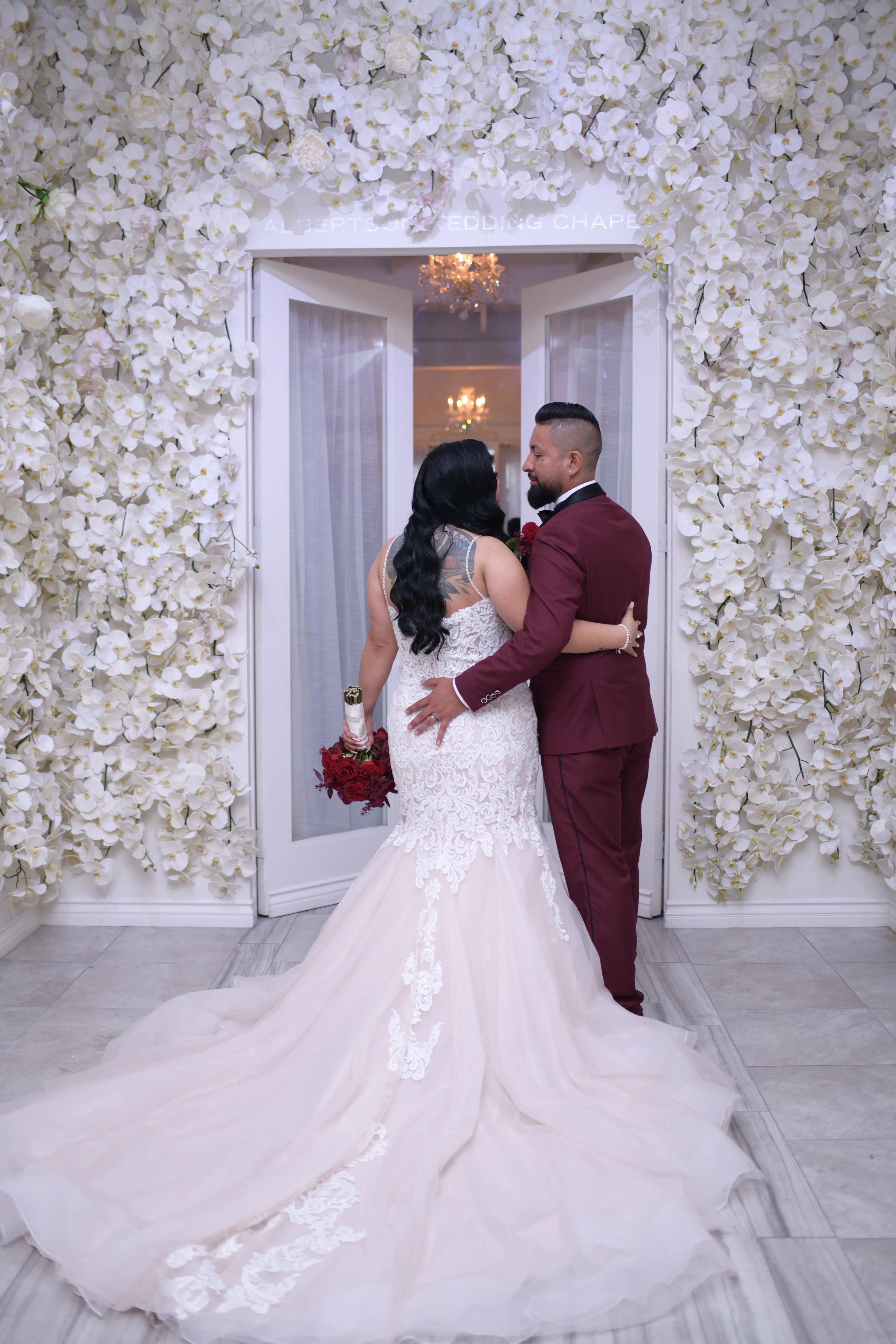 Back view of bride and groom. Bride wearing wedding dress called Alistaire Lynette.
