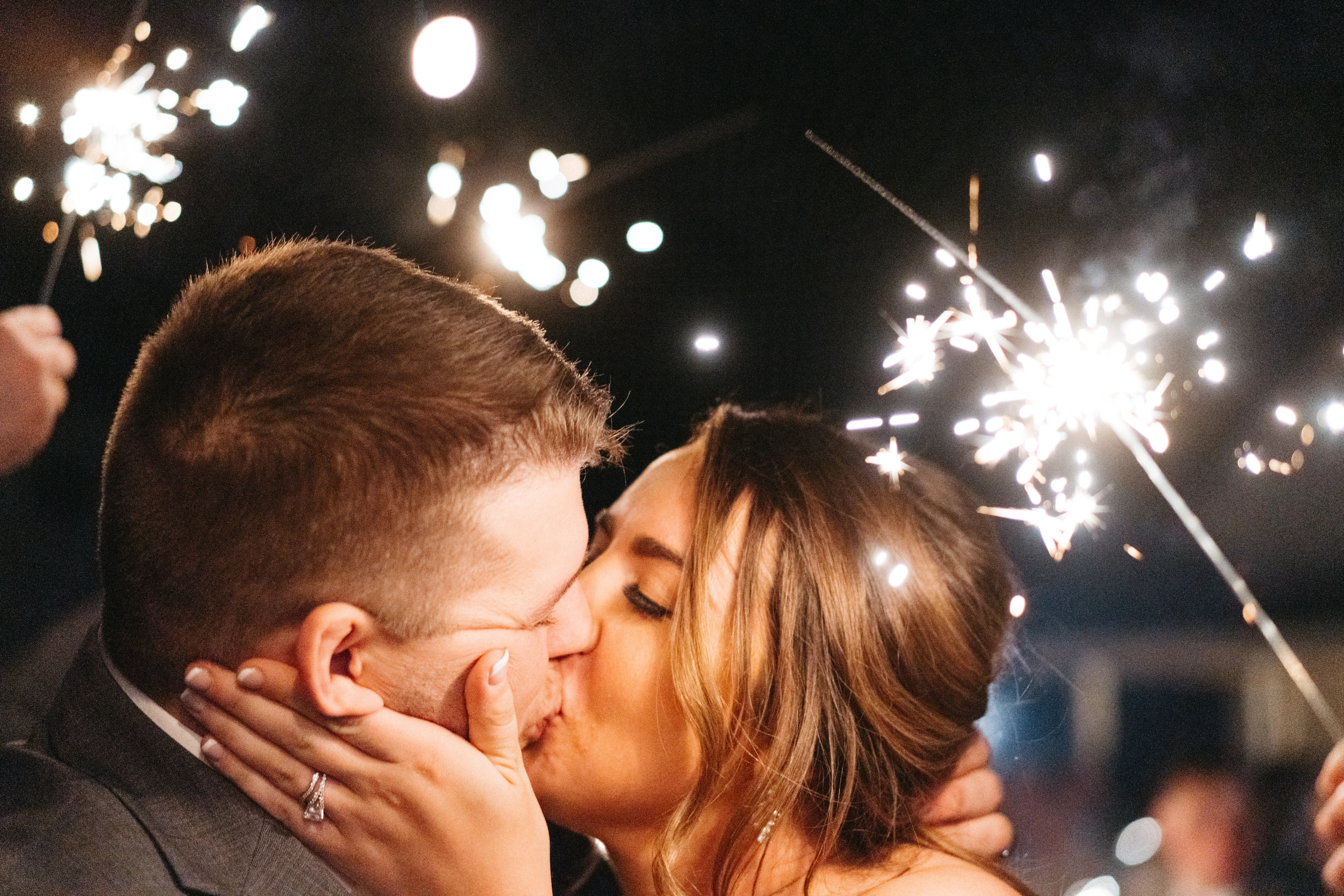 Bride Kissing Groom Surrounded By Sparklers