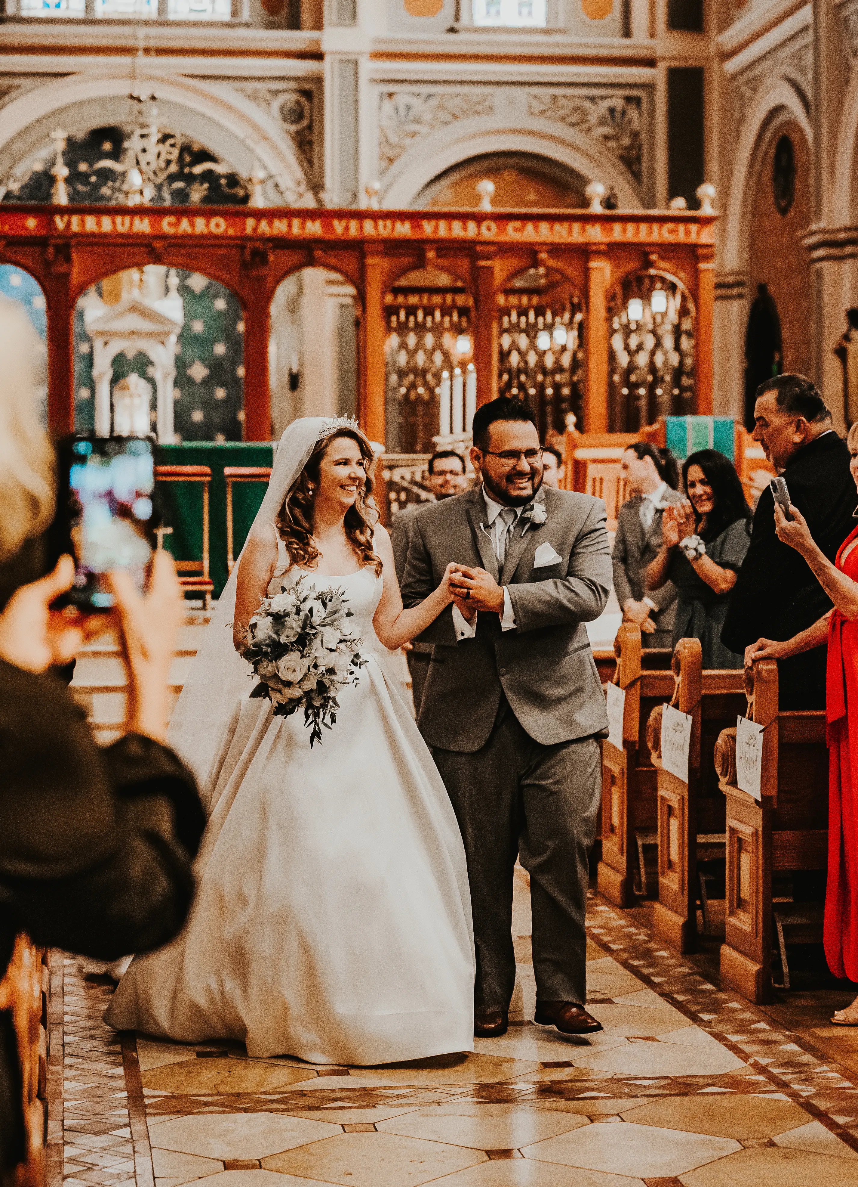 Bride And Groom Walking Down The Aisle Together. Bride In Satin A-Line Wedding Dress Called Selena By Maggie Sottero